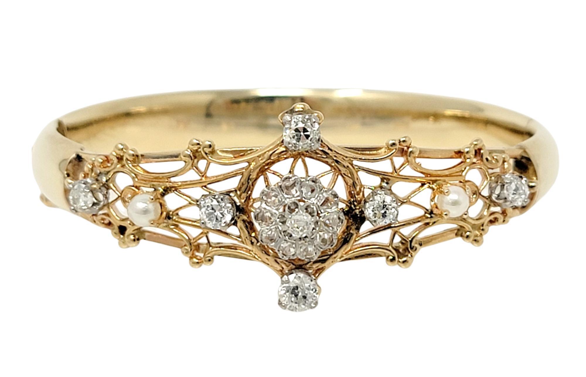 Enchanting antique bangle bracelet embellished with sparkling natural diamonds and seed pearls. This lovely piece is made of polished 14 karat yellow and rose gold and features a hinged side opening. The top half of the bracelet has an intricate