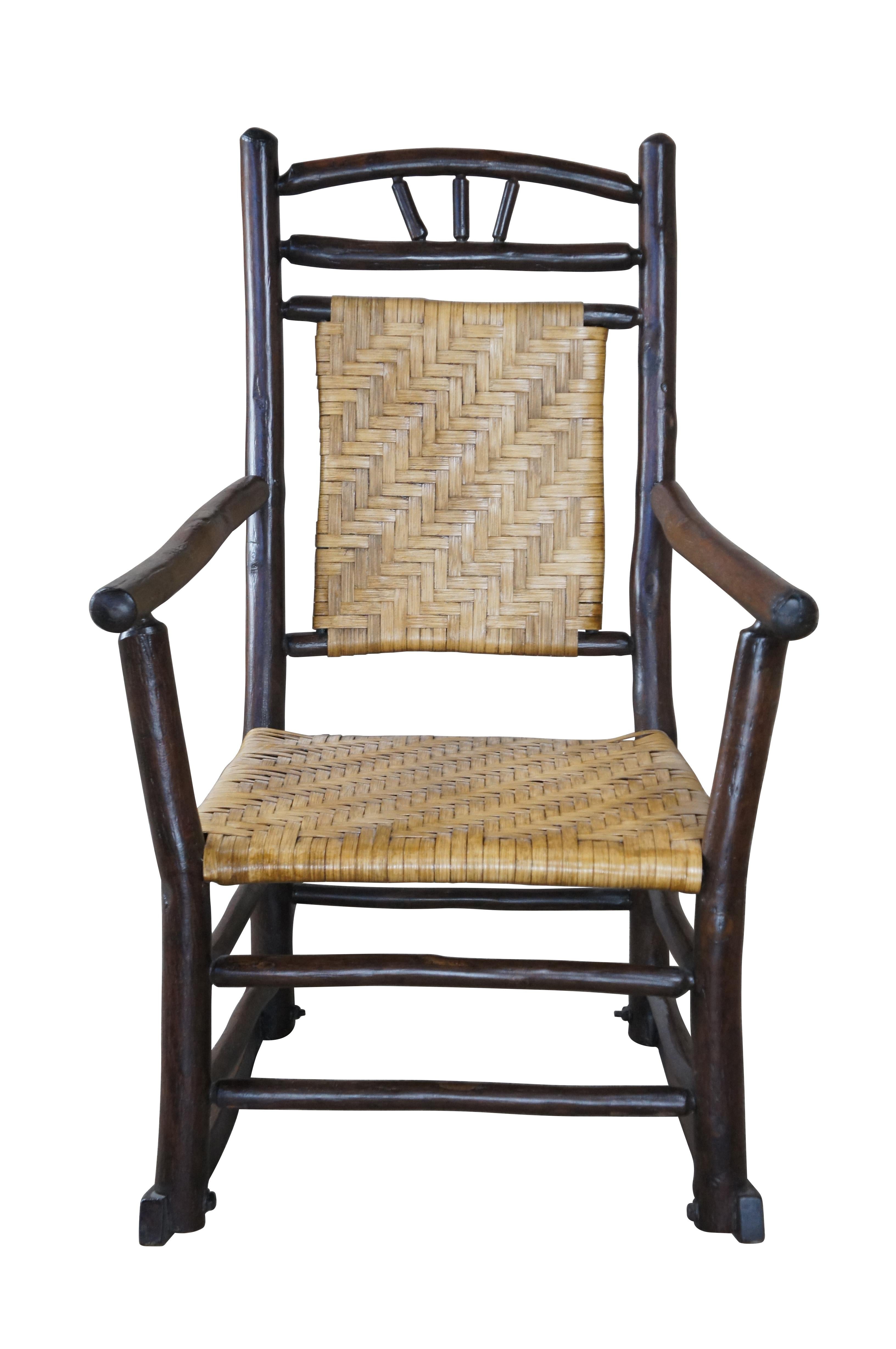 Rocking armchair by Old Hickory Furniture Company of Martinsville, Indiana. Features a primitive Adirondack style with flared arms and rattan seat.

History
In the 1800's as pioneers traveled West across America, they discovered the useful and