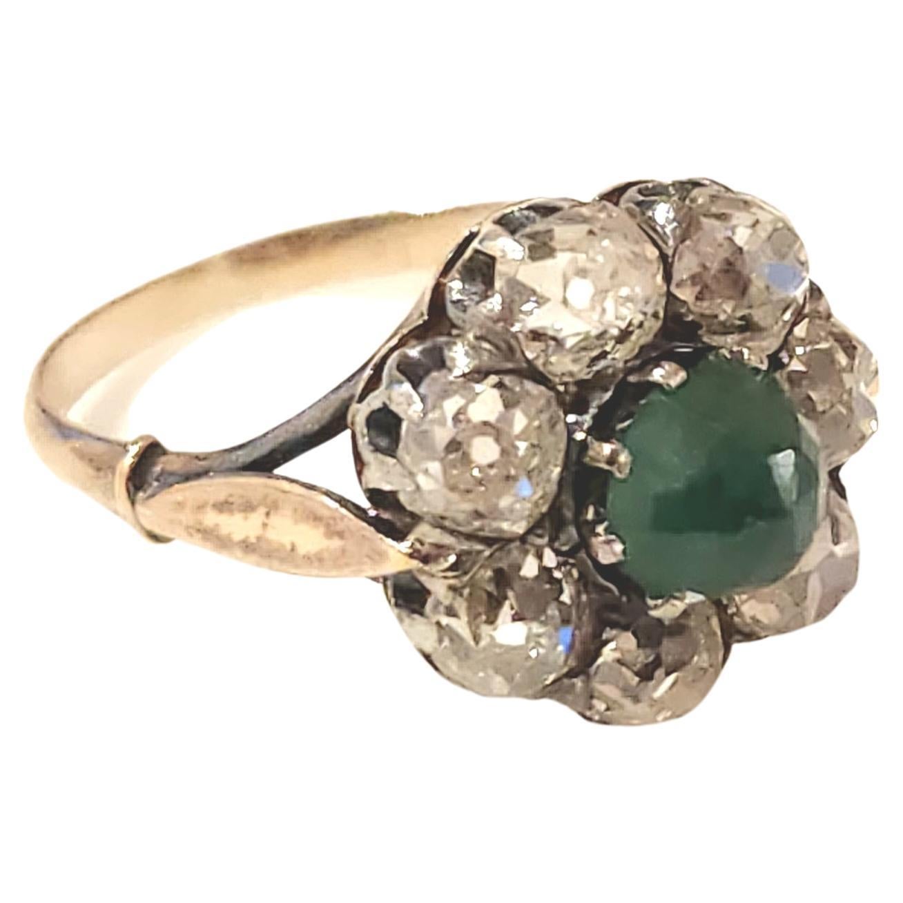 Antiguo anillo de oro de 14 quilates centrado con esmeralda verde natural flanqueada por grandes diamantes talla mina antigua con un peso estimado de 3 quilates en excelente brillo en un diseño de anillo floral que data de europa 1910.c