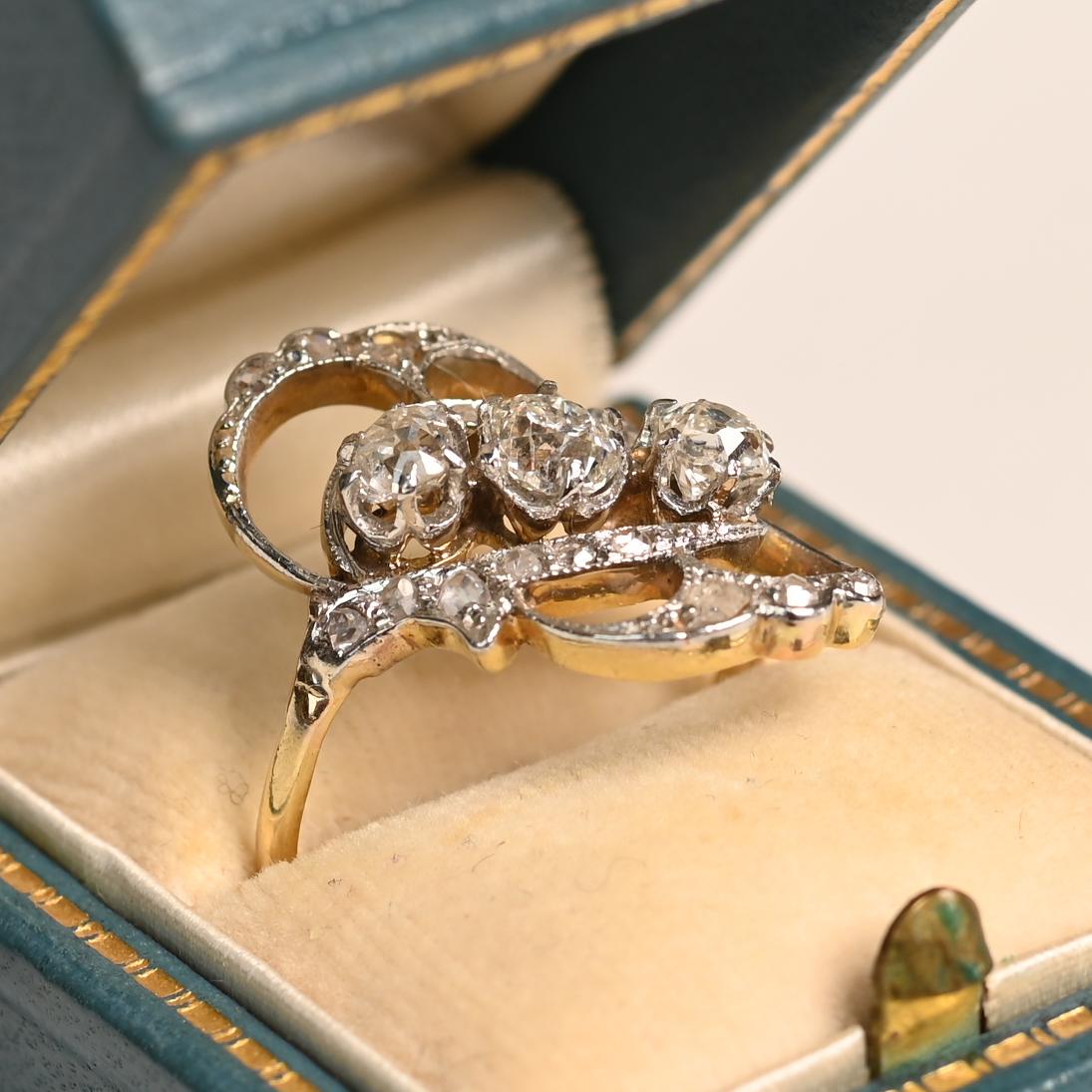 Dieser exquisite Jugendstilring aus der Zeit um 1900 besticht durch zeitlose Eleganz und meisterhafte Handwerkskunst. Das Herzstück bilden drei Diamanten im Altminenschliff, die in einer anmutigen diagonalen Reihe angeordnet sind und zusammen ein
