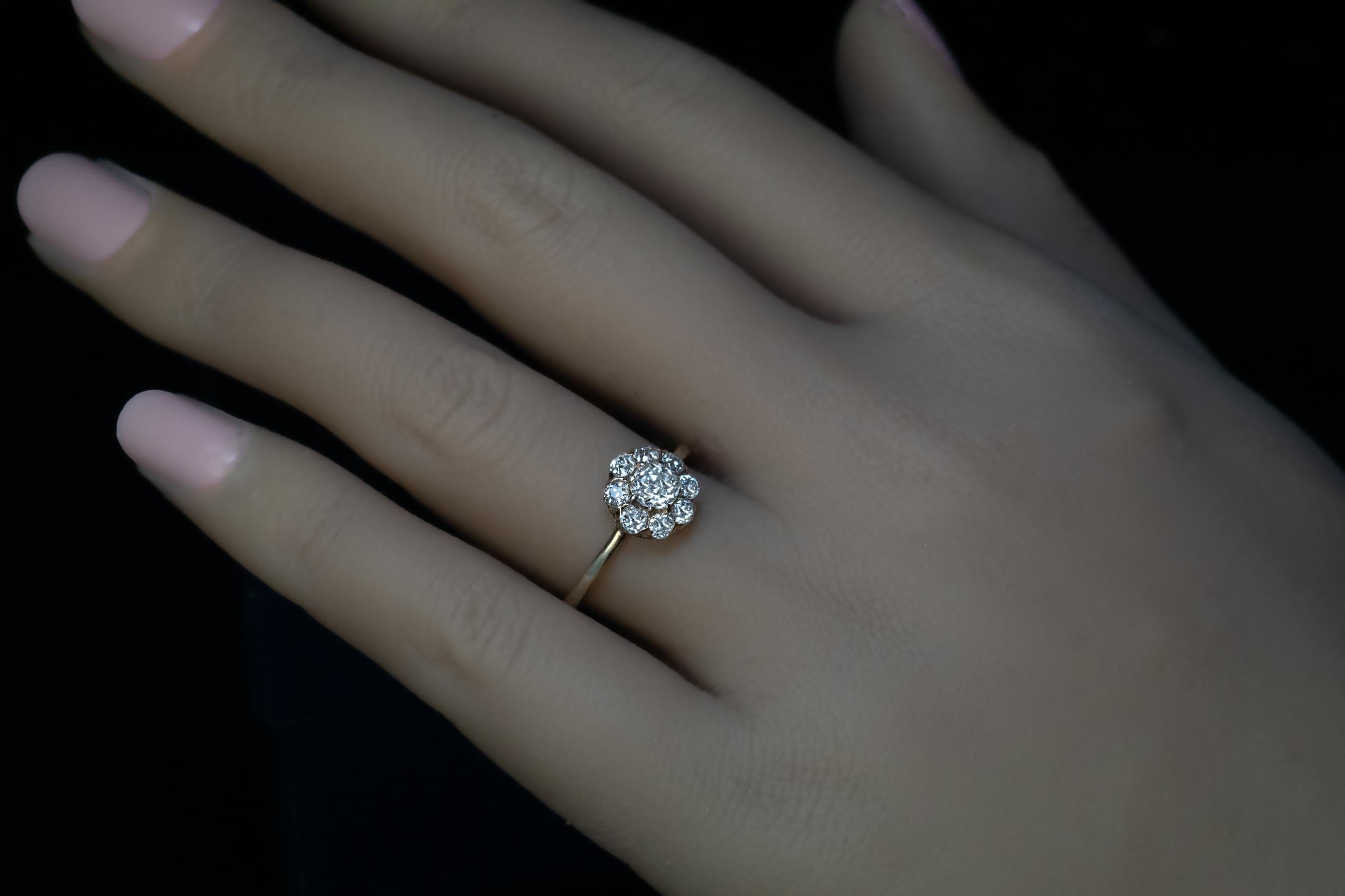 Russia, circa 1900.
This classic antique 14K gold cluster ring is set with bright white old mine cut diamonds. The center stone is approximately 0.46 ct. (G color, VS1 clarity), the smaller diamonds are F-G color, SI clarity.
Estimated total diamond