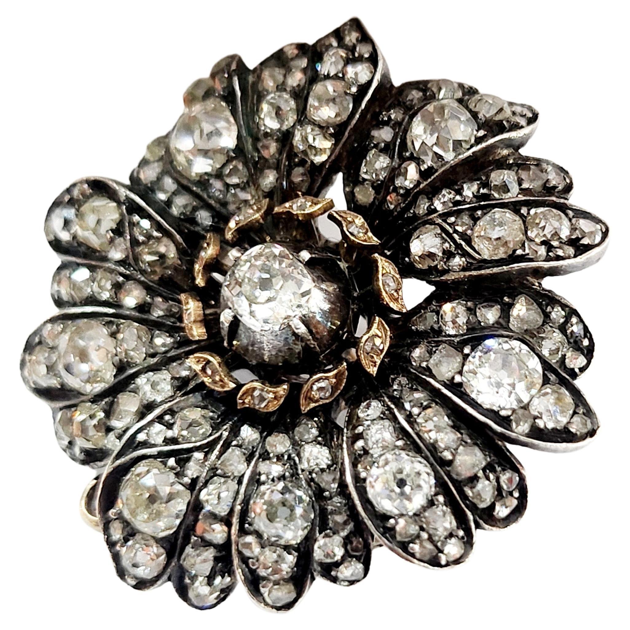 Antique victorian old mine cut diamond large flower head brooch and pendant with estimate diamond weight of 4.5 carats centered with a large old cut diamond flanked with smaller diamonds in a floral designe 14k gold topped with silver dates back to