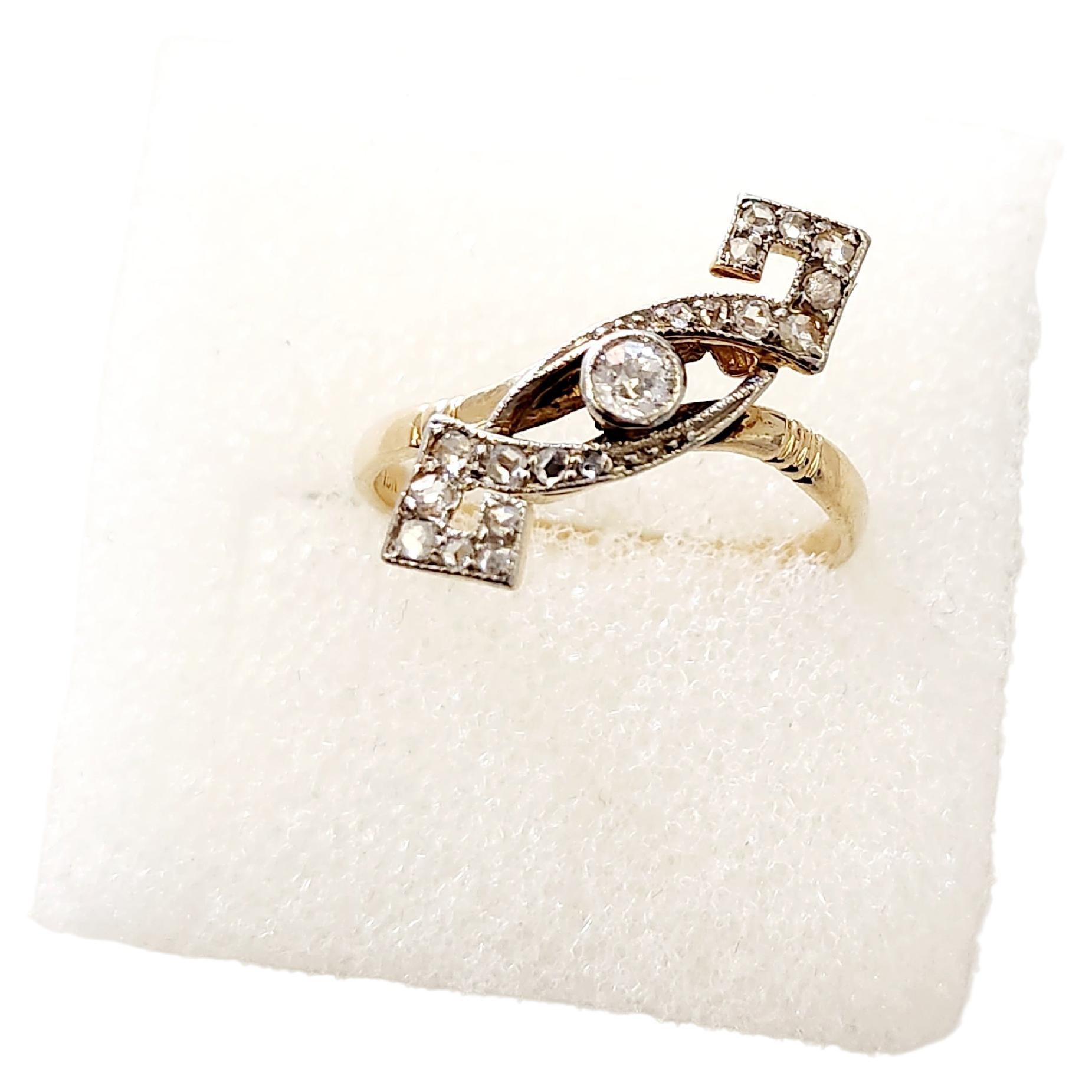 Anillo antiguo de oro de 18 quilates centrado con 1 diamante talla antigua con un peso estimado de 0,17 quilates flanqueado por diamantes talla antigua más pequeños en diseño gemotrice el anillo lleva la marca hall 750 y la inicial del fabricante el