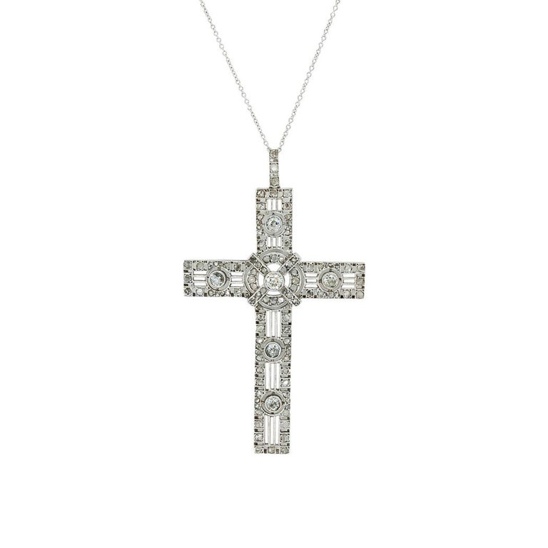 Antique diamond and platinum cross pendant circa 1900.  

SPECIFICATIONS:

DIAMONDS:  one hundred fifteen old mine and rose-cut diamonds totaling approximately 1.55 carats, approximately H-K color, SI-I clarity.

PENDANT METAL:  platinum.

WEIGHT: 