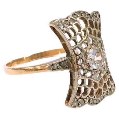 Early art deco era antique 14k ring topped with platinum in an open work style ribbon ring head designe centered with 1 old mine cut diamond estimate weight of 0.50 carats H color white dates back to europe 1910s