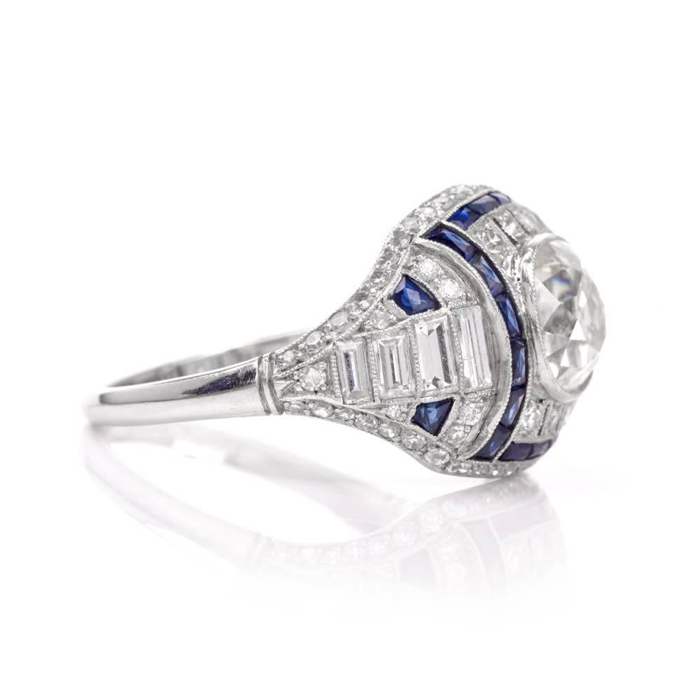 This captivating antique engagement ring of classic charm and sophistication is crafted in solid platinum. Elaborately designed as a stunning dome shaped plaque, it is centered with a prominent stunning old-mine cut diamond approx. 2.15cts, L-M