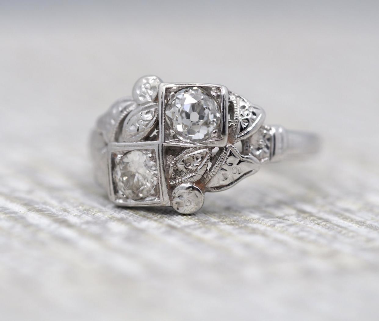 Item Description:

This is a very unique engagement ring with two old miner cut diamonds. The total weight of both diamonds combined is approximately .55cttw. Surrounding both diamonds are beautiful floral hand carved designs which have a floral
