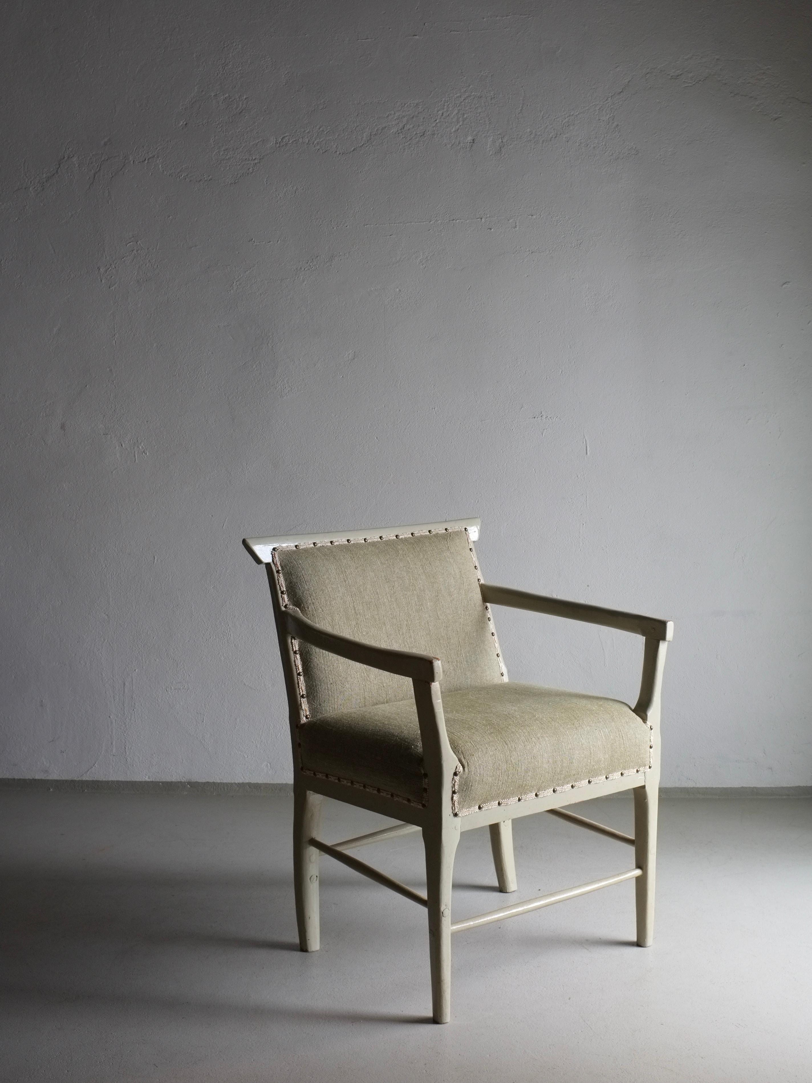 Fauteuil vintage suédois peint en vert-gris avec un nouveau revêtement en lin lavé vert olive. Le ruban de décoration a été laissé d'origine pour préserver le caractère de la chaise.
