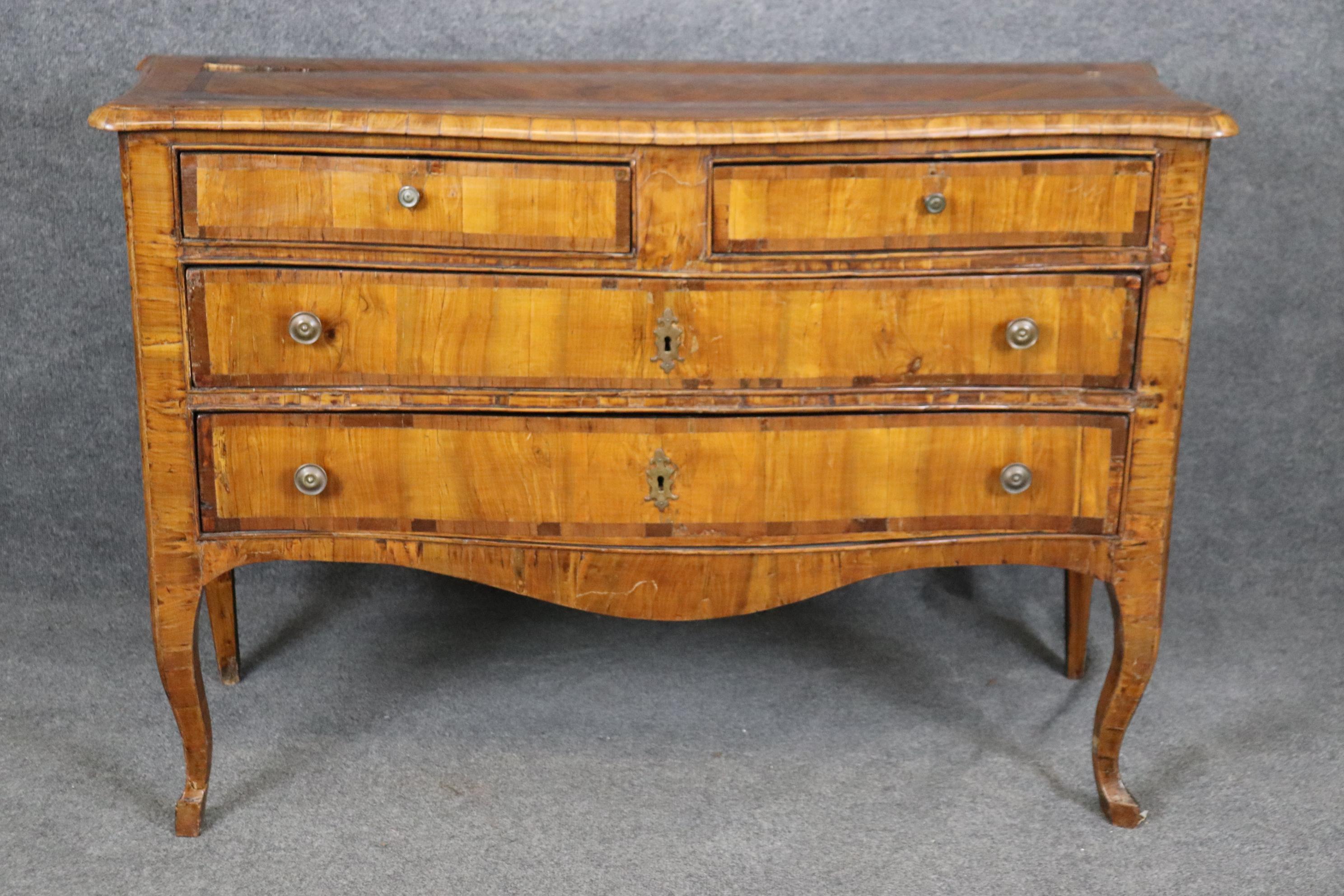 This is a gorgeous antique middle 1740s -1780s era Italian Made commode. The commode is made of Olive wood and designed in the Louis XV style. The piece has its original patina and old repairs, patches, and signs of wear and use that are to be