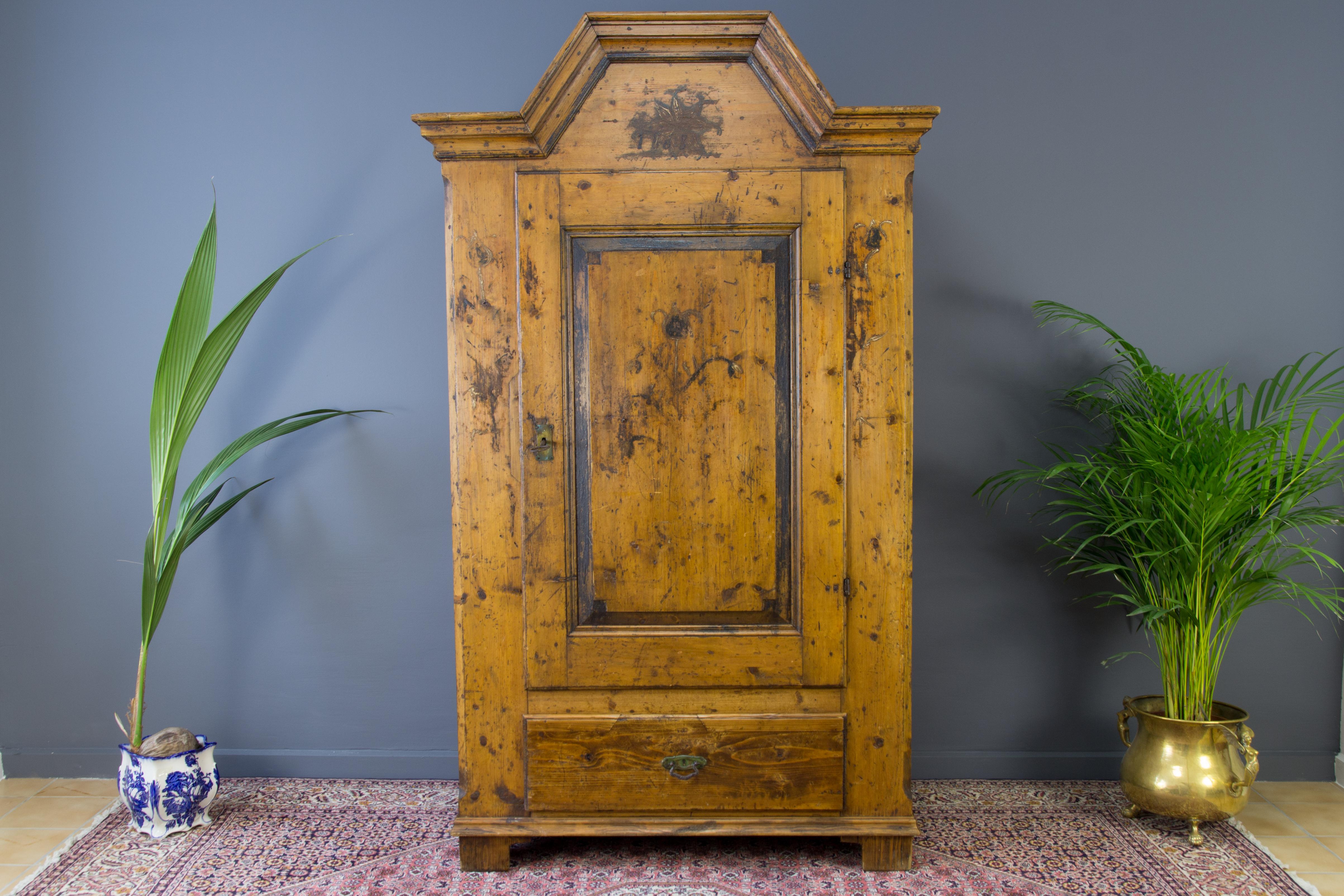 This unique and antique one door Baltic pine armoire or wardrobe was handcrafted in late 19th century. On the armoire is dated 1868, but it could be made earlier. There are two shelves, one interior and one exterior drawer. Very decorative and