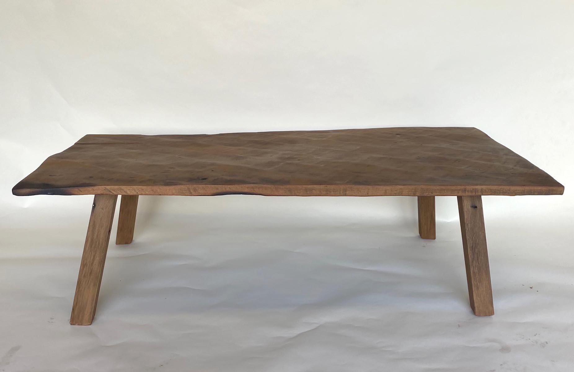 Beautiful rustic hand hewn antique one wide board top from Guatemala fashioned into a coffee table with straight simple legs. Top is slightly warped but still very usable.