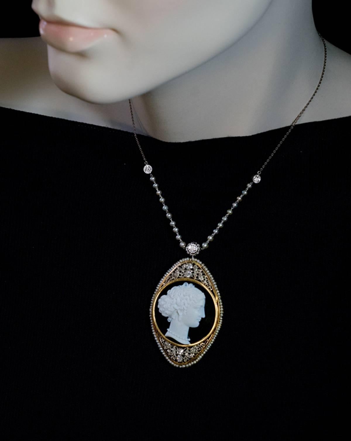 This superb Renaissance style antique diamond and seed pearl necklace features a black and white onyx (agate) cameo finely carved with a profile of a lady.  The cameo is set in an ornate 14K white and yellow gold openwork bezel embellished with