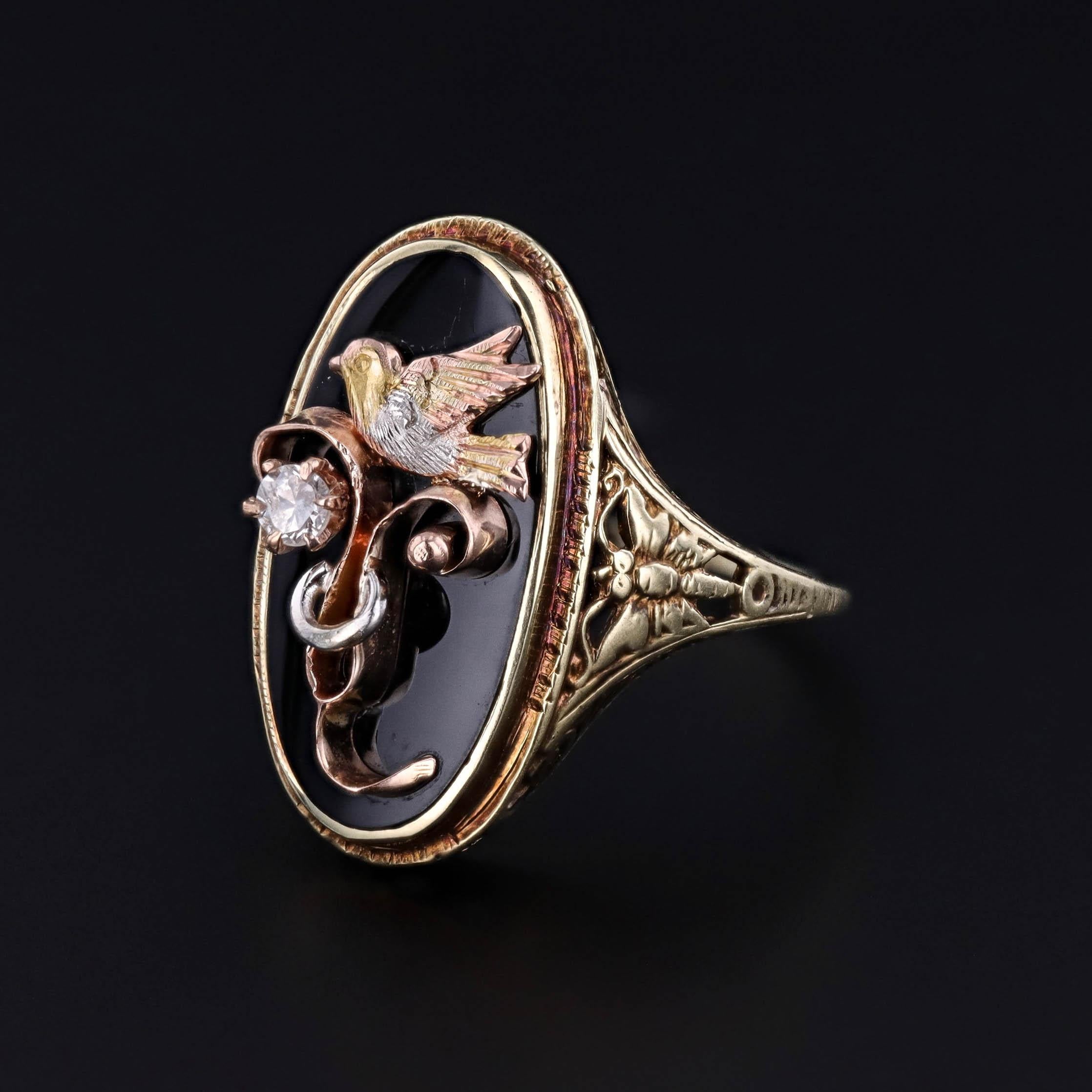 Creamos esta pieza única remachando una punta de alfiler de gancho antigua (circa 1910) en un anillo de sello de los años 20.

El anillo de oro de 14k presenta un pájaro de oro tricolor con un 