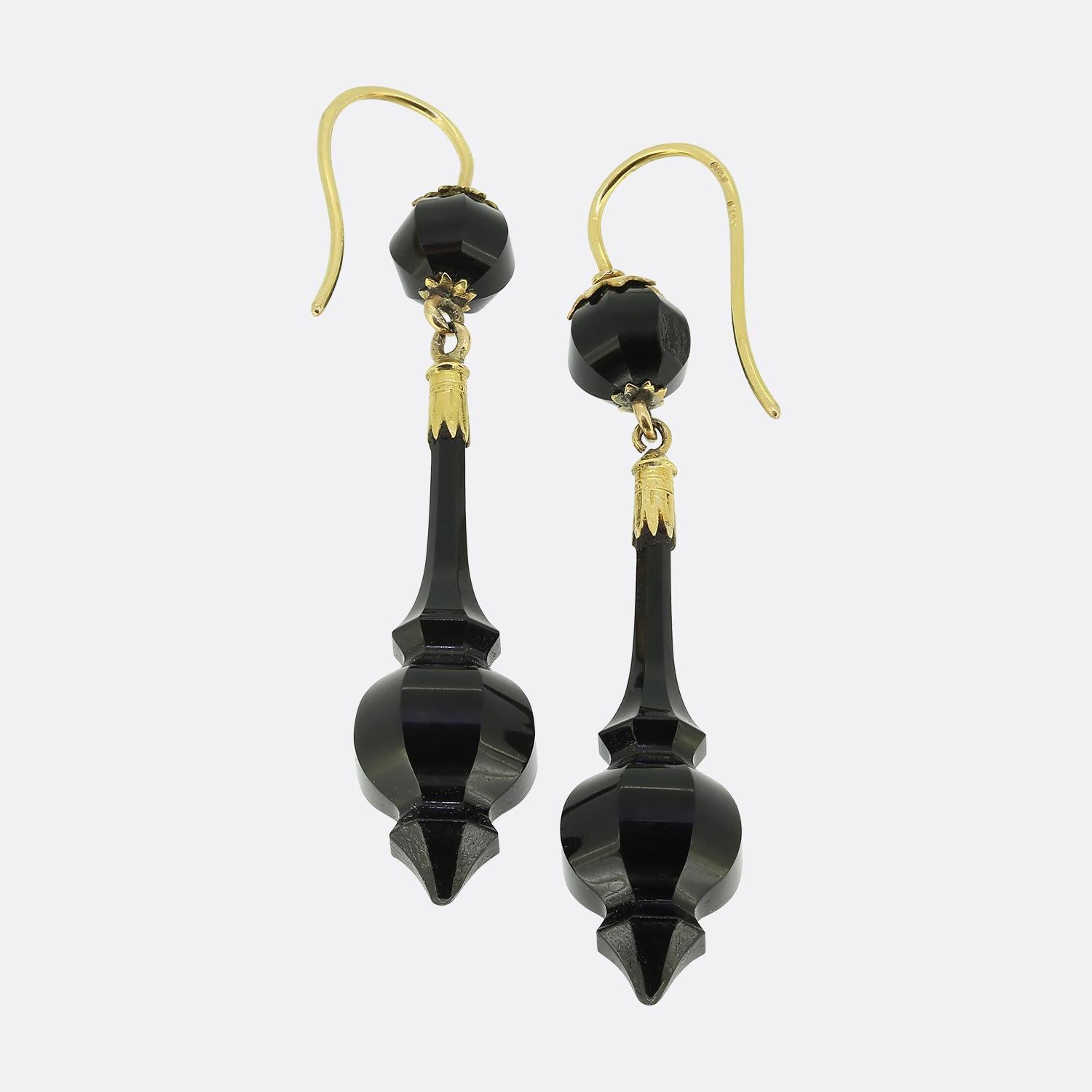 Here we have a splendid pair of drop earrings taken from the Victorian era. Each identical piece has been expertly hand crafted from striking jet black onyx into an ornate elongated  shape. The polished onyx is complemented by rich 18ct yellow gold