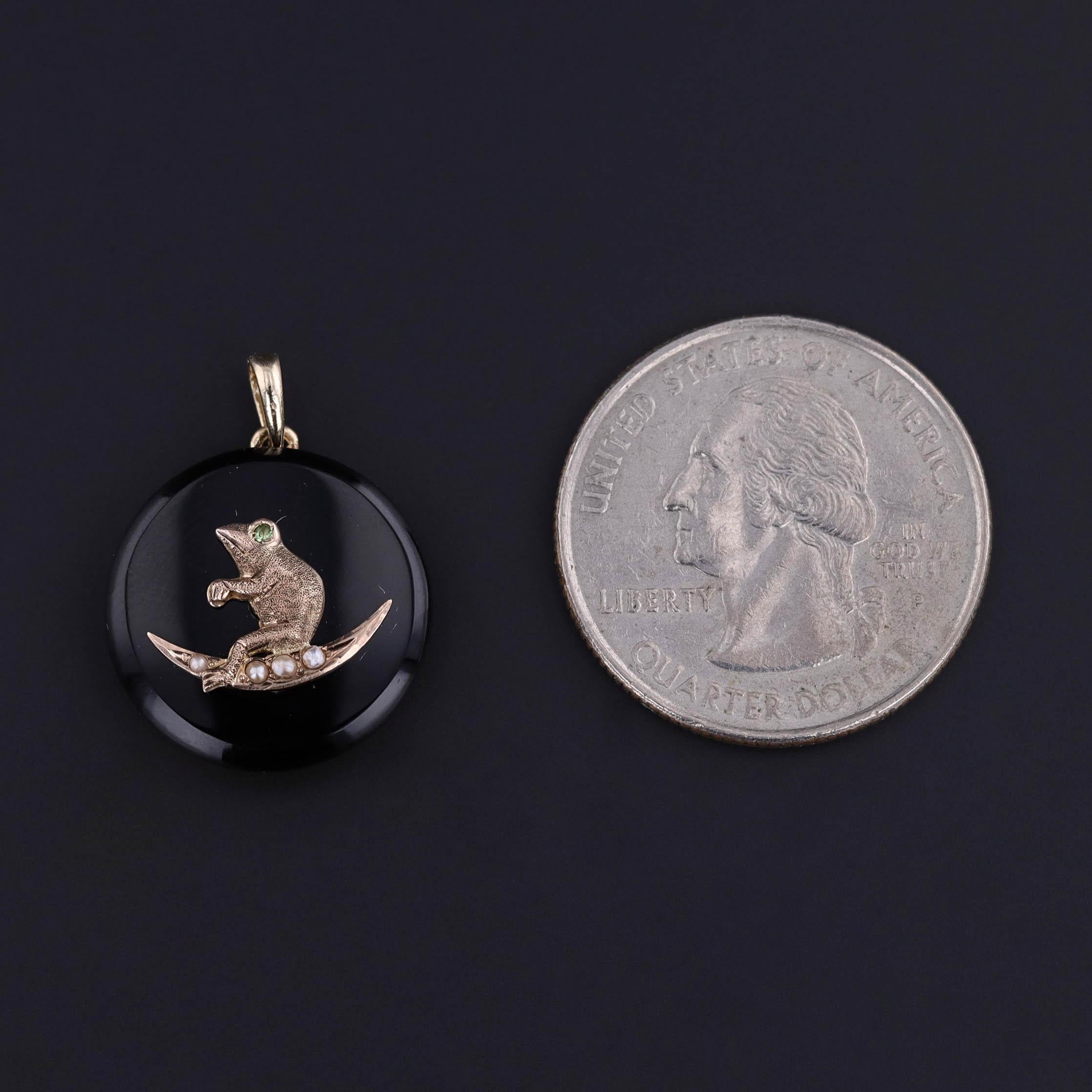 An onyx pendant with a 10k gold frog with a demantoid garnet eye on a pearl crescent in a 14k gold mounting. It was created from an antique onyx bracelet (circa 1900) and an antique stickpin head (circa 1890).

The piece measures 0.9 inches from the