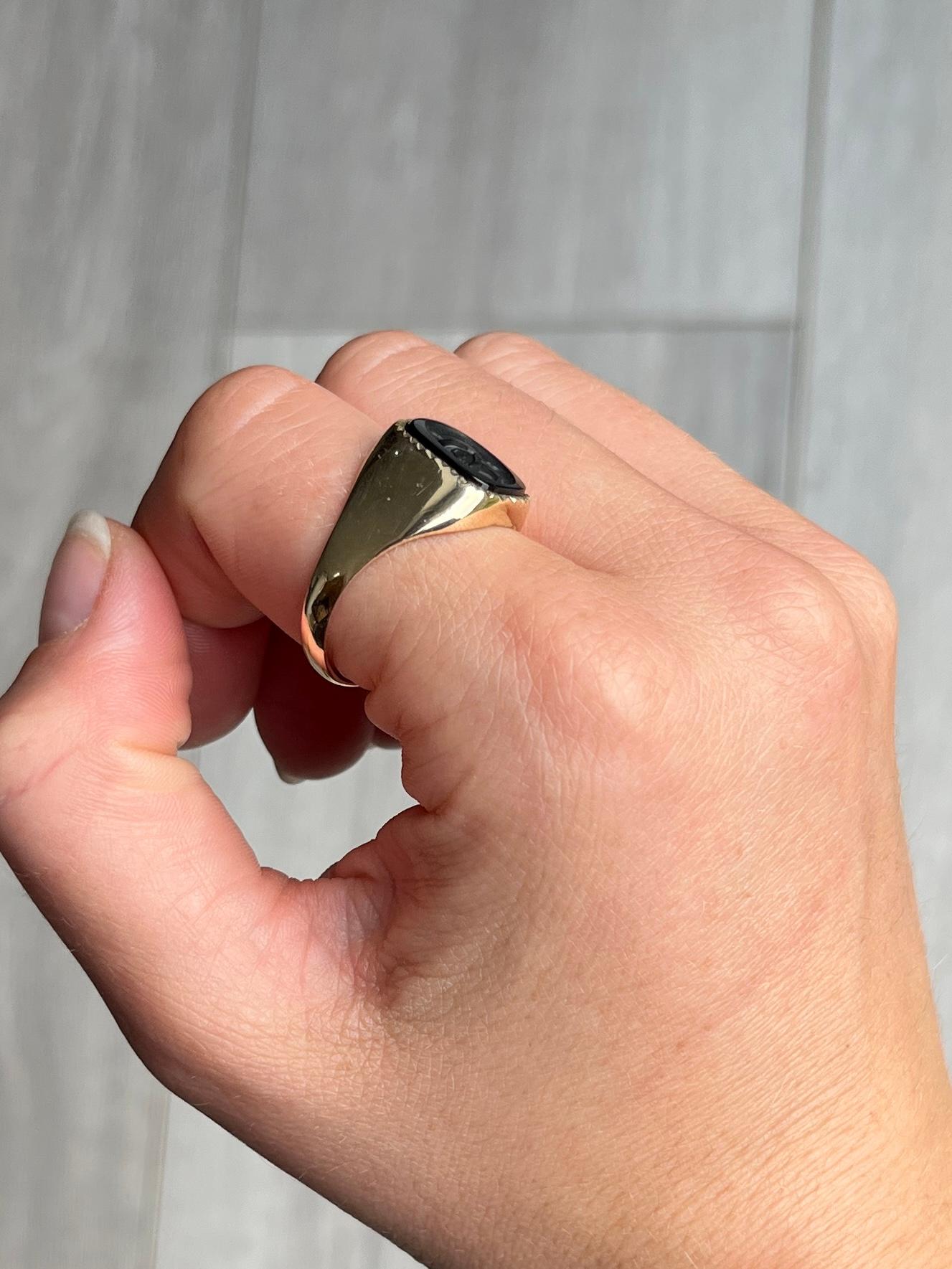 The black stone next to the glossy gold is just gorgeous! The stone has an intaglio of a centurion. 

Ring Size: V or 10 1/2  
Stone Dimensions: 12x10mm 

Weight: 4.1g

