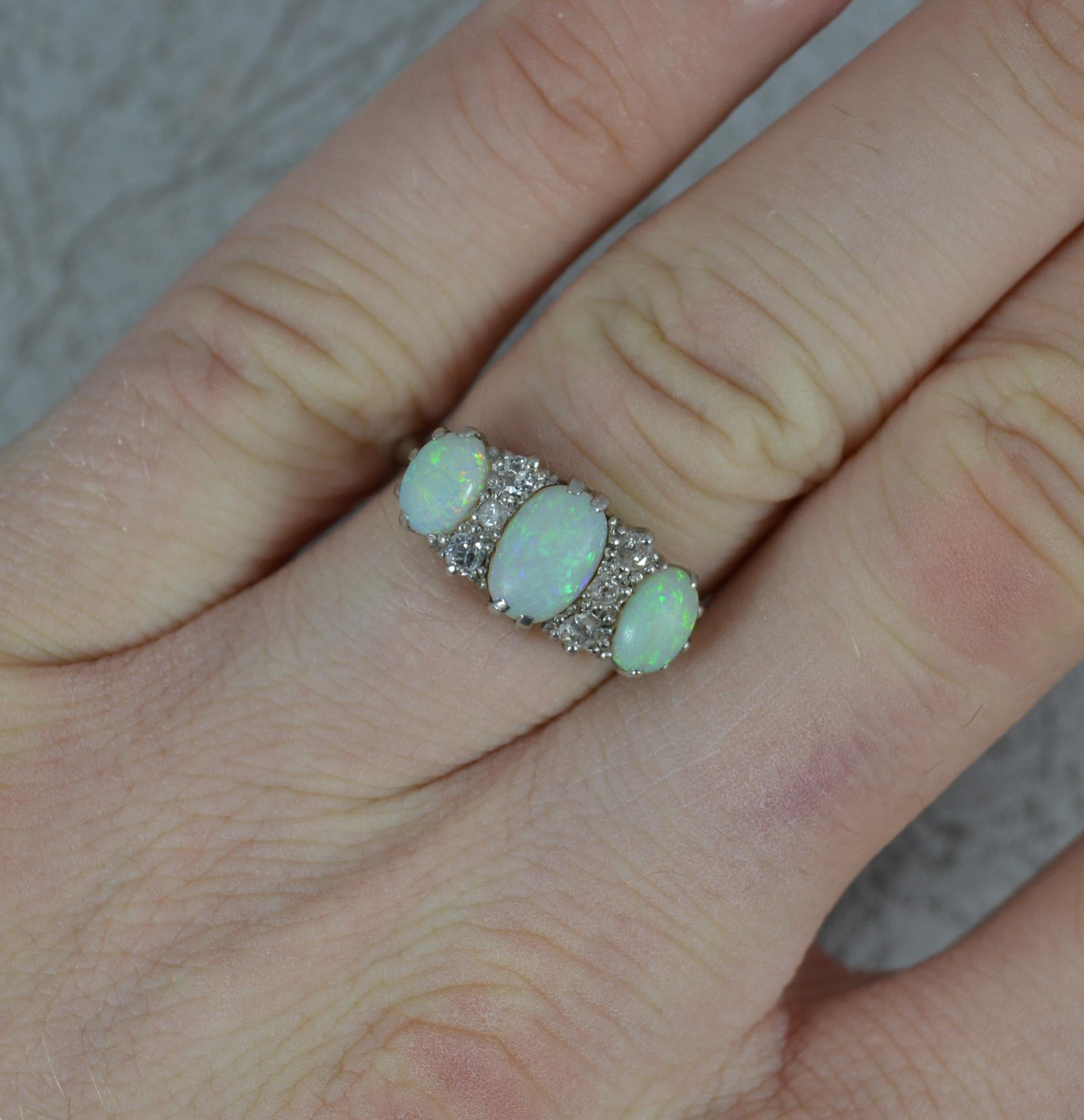 A superb Opald and Diamond cluster ring.
Solid 18 carat white gold example.
Set with three natural oval shaped opals with three natural diamonds in between. 5mm x 8mm central opal. Wonderful colour and quality stones, well matched.
17.5mm x 8mm