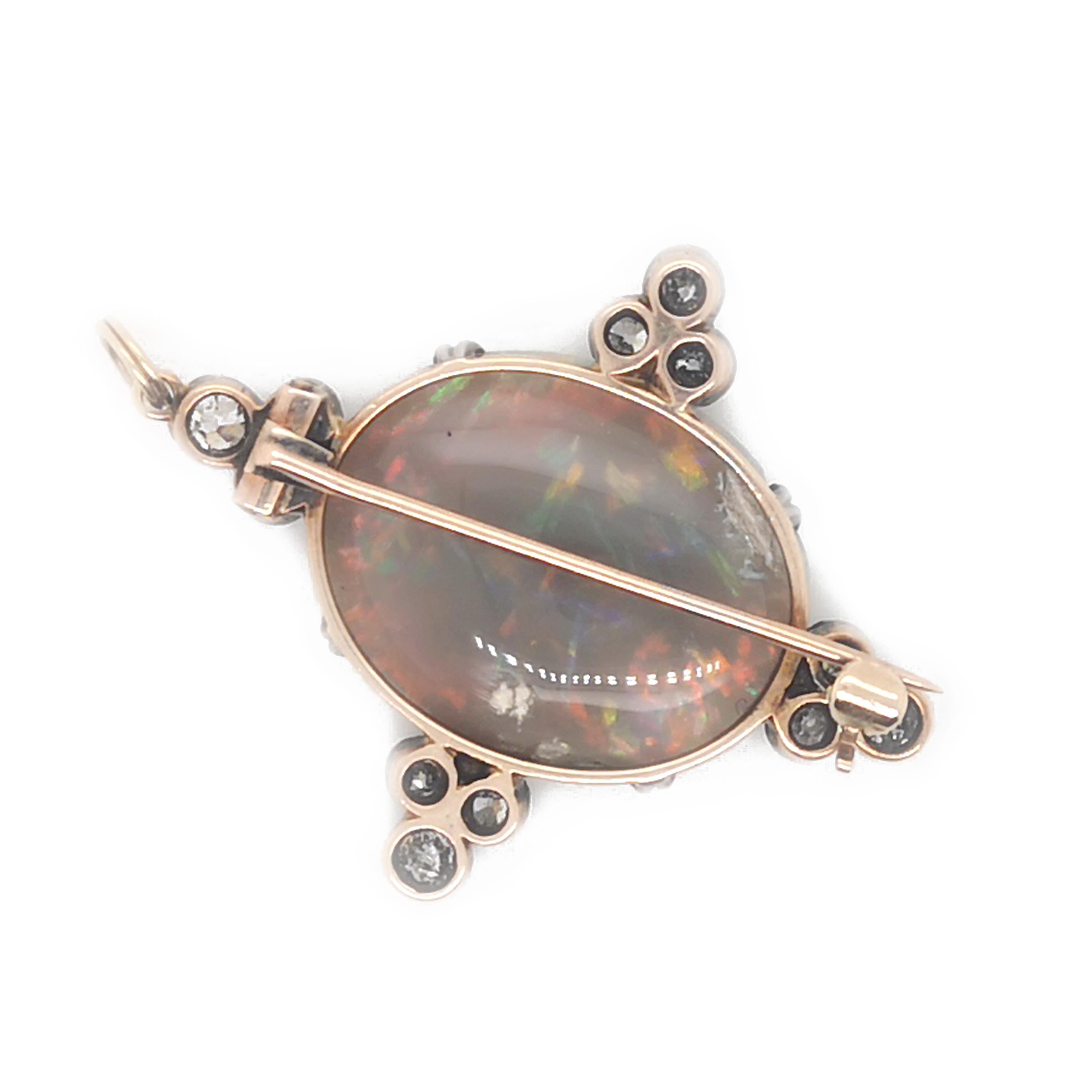 An antique opal and diamond brooch, with an opal with a predominantly red play of colour, mounted in gold, with four groups of three old-cut diamonds, in silver-upon-gold, millegrain edged, rub over settings, with a loop to convert to a pendant,