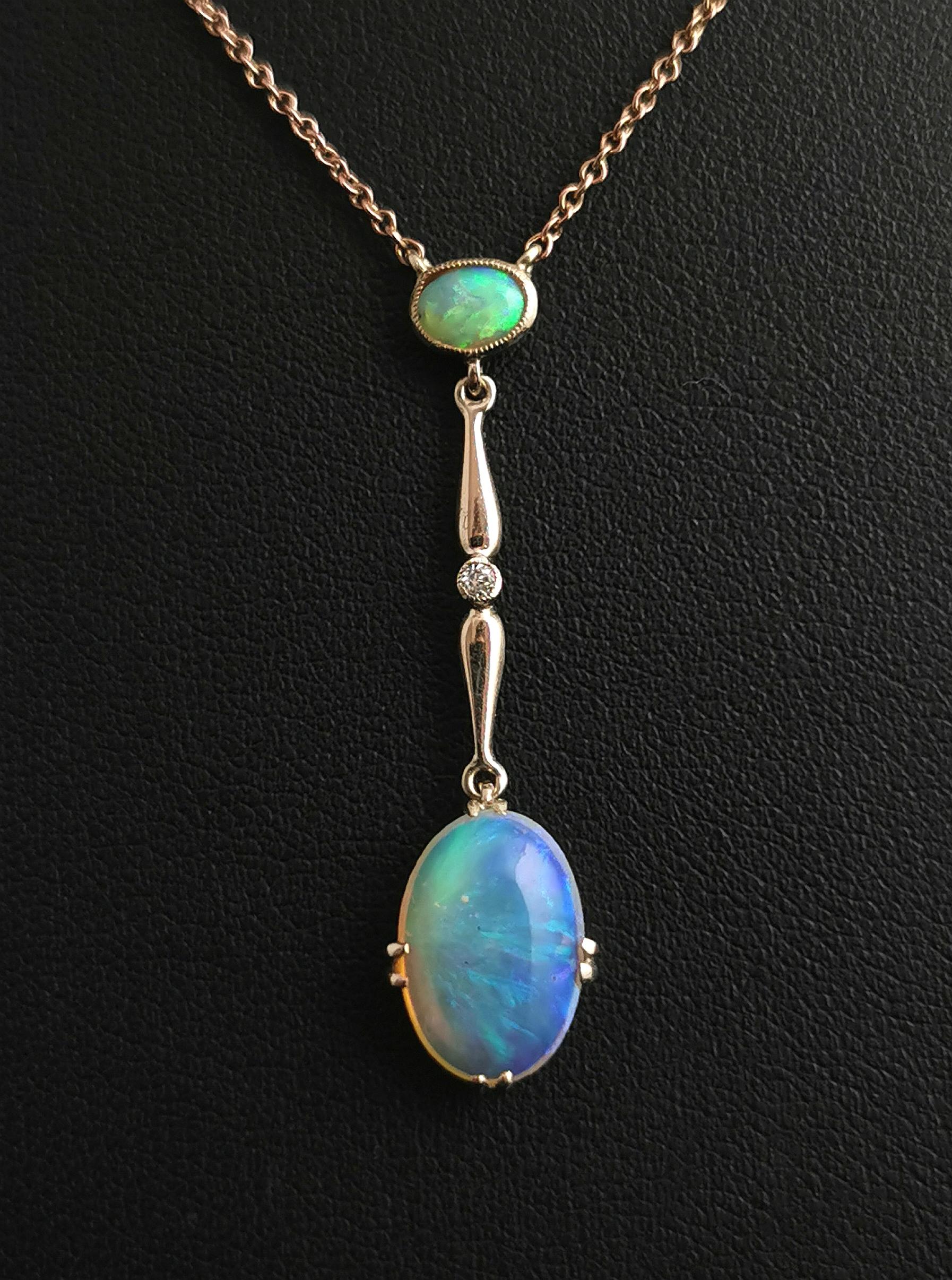 A beautiful and delicate antique Art Deco era Opal and Diamond drop pendant necklace.

The pendant takes centre stage and is set with a bright and firey opal to the top in a gold bezel, there is a gold bar drop set with a single cut diamond and from