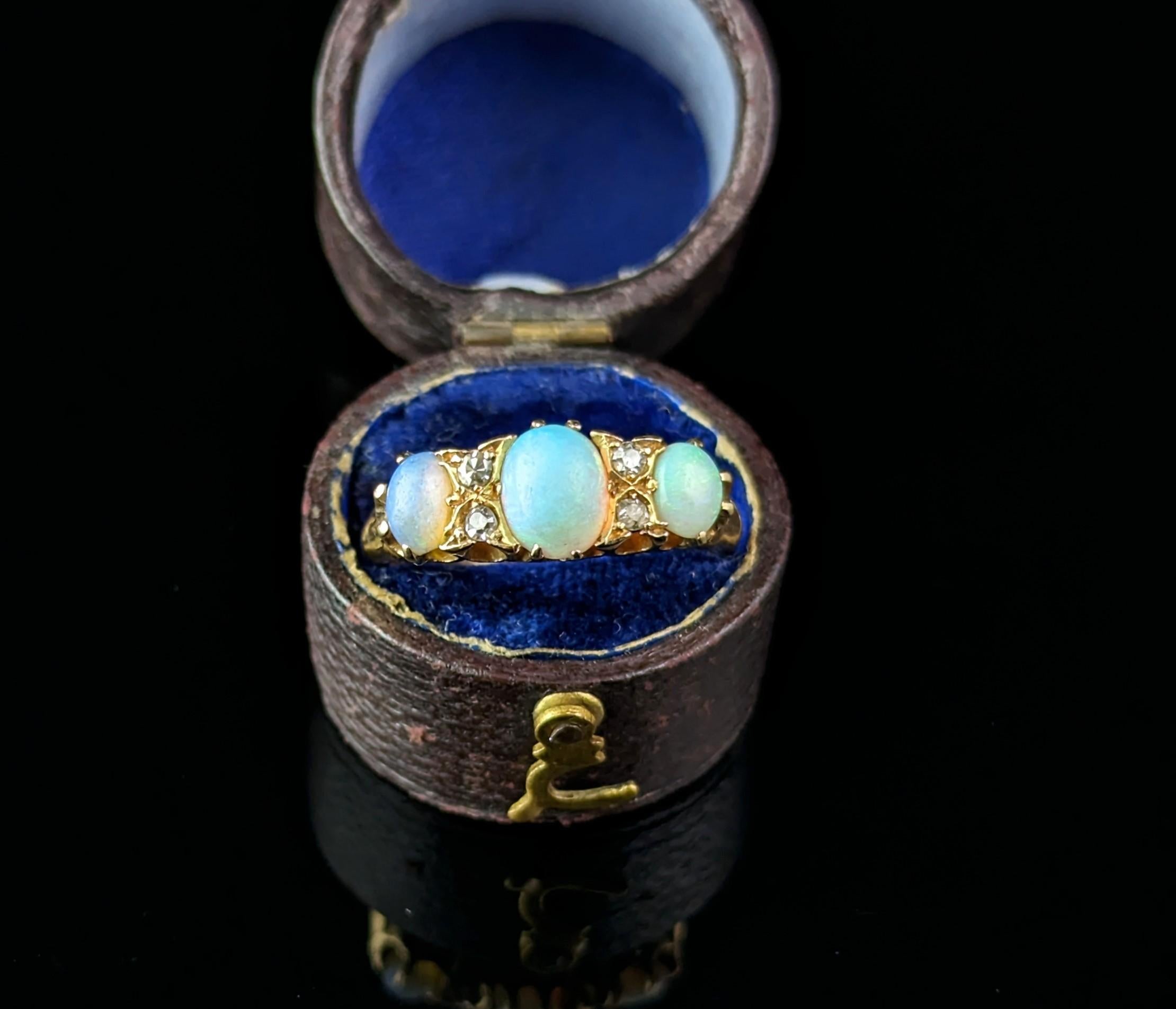 You can't help but be enchanted by this gorgeous antique, Edwardian era opal and old cut diamond ring.

A rich 18ct yellow gold band with a boat head style setting and decorative engraved shoulders.

The face is set with three beautiful opal