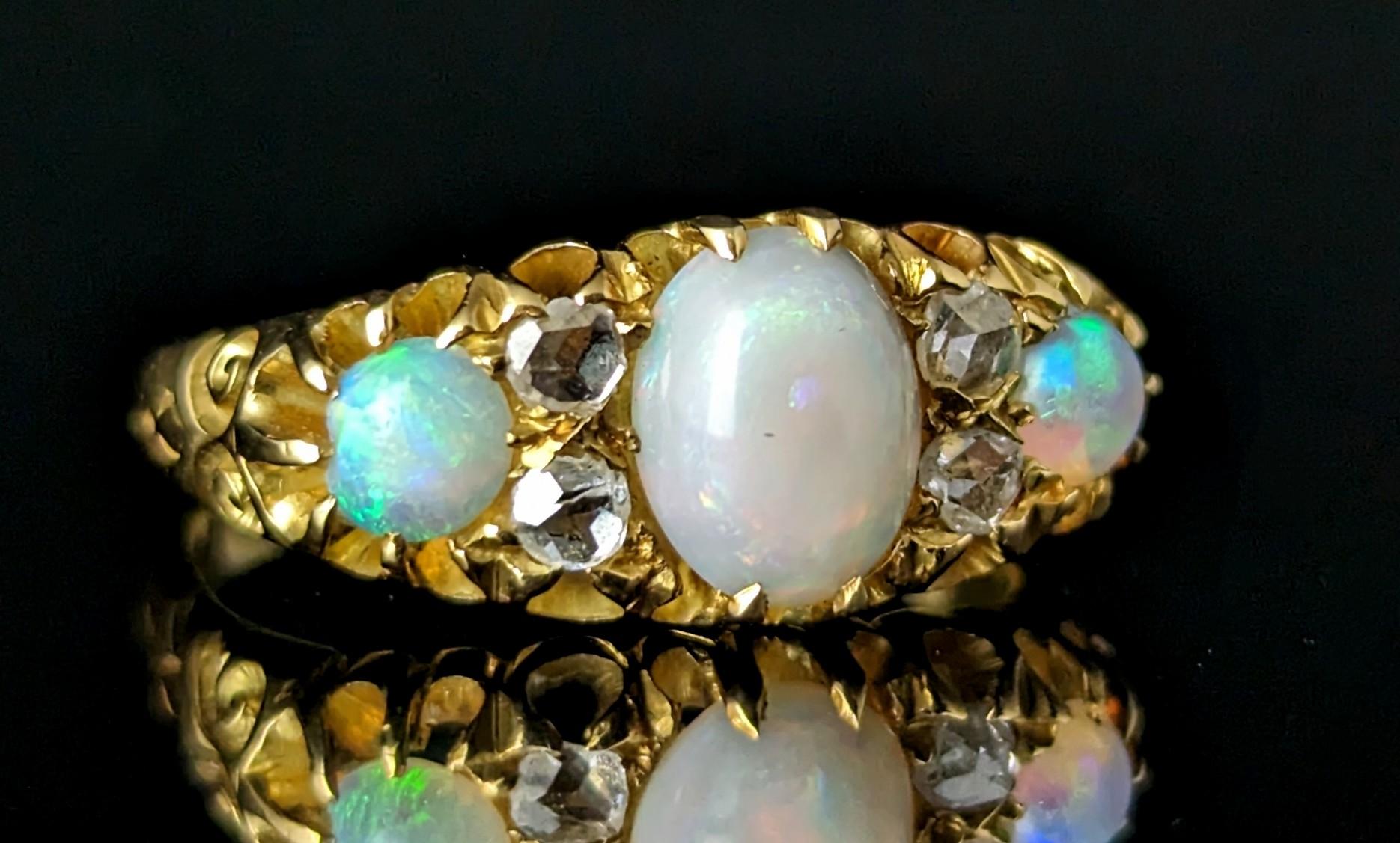 You can't help but be enchanted by this gorgeous antique, Edwardian era opal and old cut diamond ring.

A rich 18ct yellow gold band with a boat head style setting and decorative carved shoulders.

The face is set with three beautiful opal