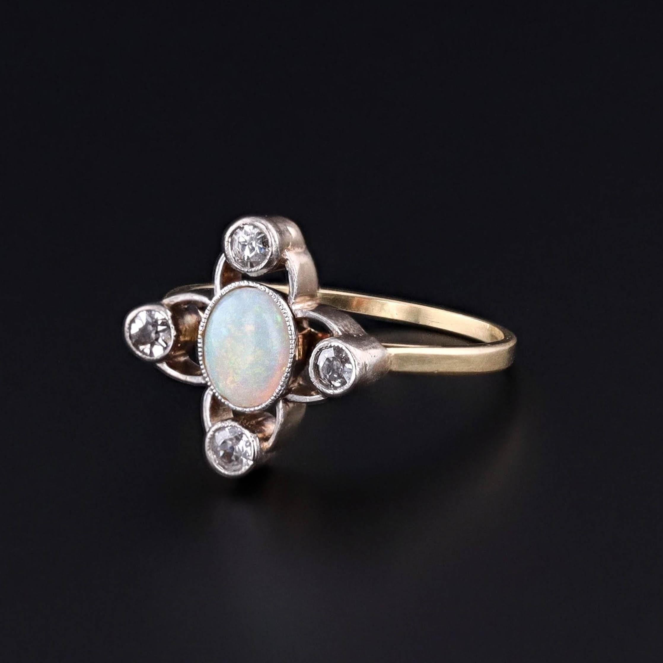 Antique Opal and Diamond Ring: This ring features an opal with four old single cut diamonds set in palladium. The face of the ring was originally an antique stickpin (circa 1880) that our jeweler transformed by removing the pin and adding a 14k gold