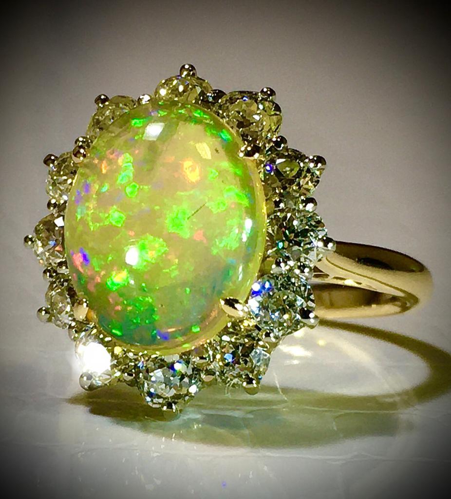 Antique Opal Diamond Ring. Diamond are antique rose cut. 12 diamonds each approx. 0,20 ct, total 2,4 ct. The bang of the ring is 18k yellow gold. Opal of exquisite quality. No chips or cracks. Ring can be resized. 

The form of the ring is