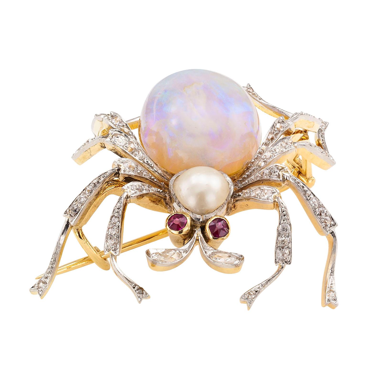 Antique opal diamond ruby pearl gold and platinum spider brooch circa 1900.

DETAILS:
Antique gem-set spider brooch mounted in platinum and gold.
GEMSTONES: two round rubies, one large oval opal and one pearl.
DIAMONDS: fifty-eight round diamonds