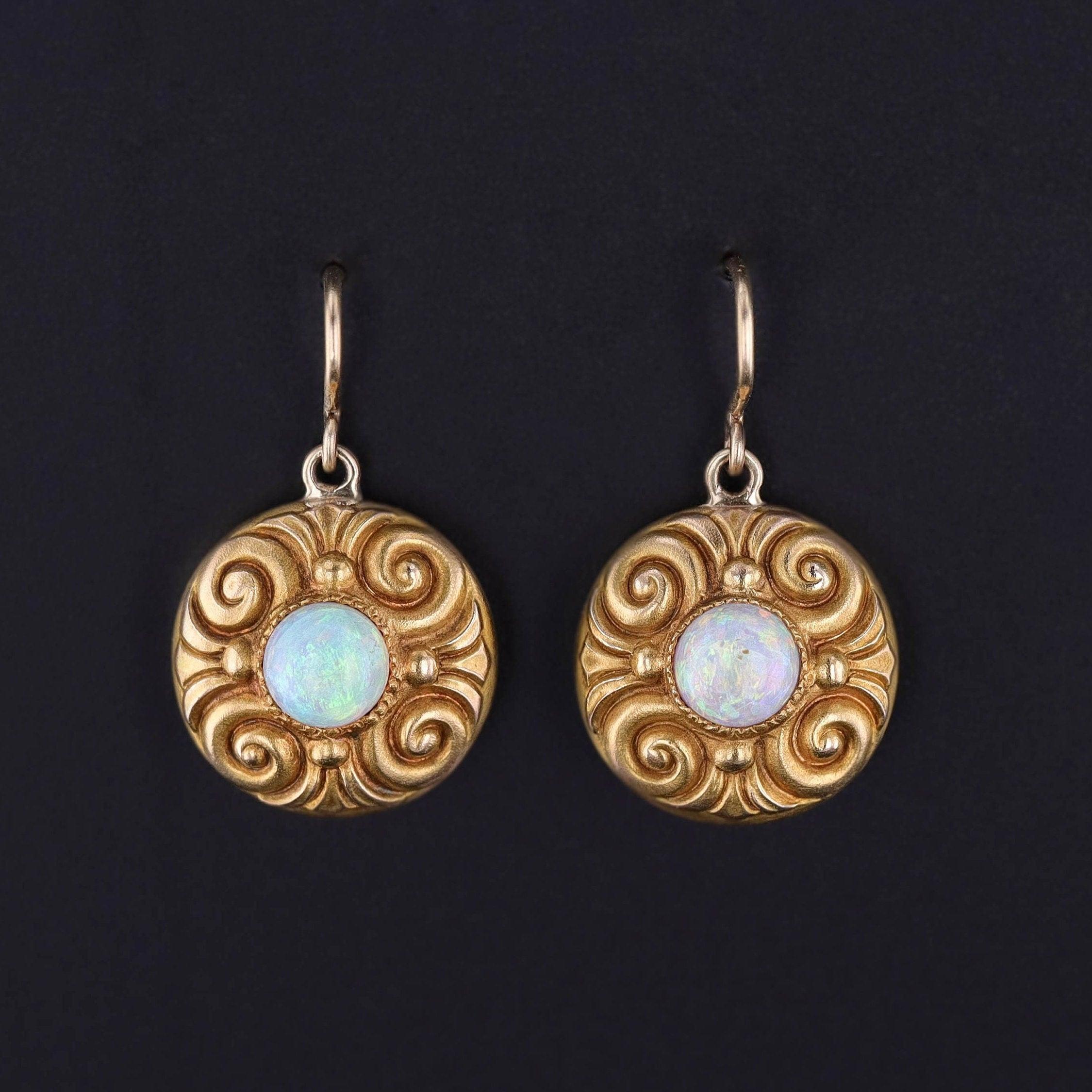 Elegantes colgantes con ardientes ópalos blancos montados en oro de 14k. 

Los pendientes eran originalmente un par de pendientes de camisa antiguos (circa 1880-1900). Nuestro joyero transformó los pasadores de camisa en pendientes, quitándoles la
