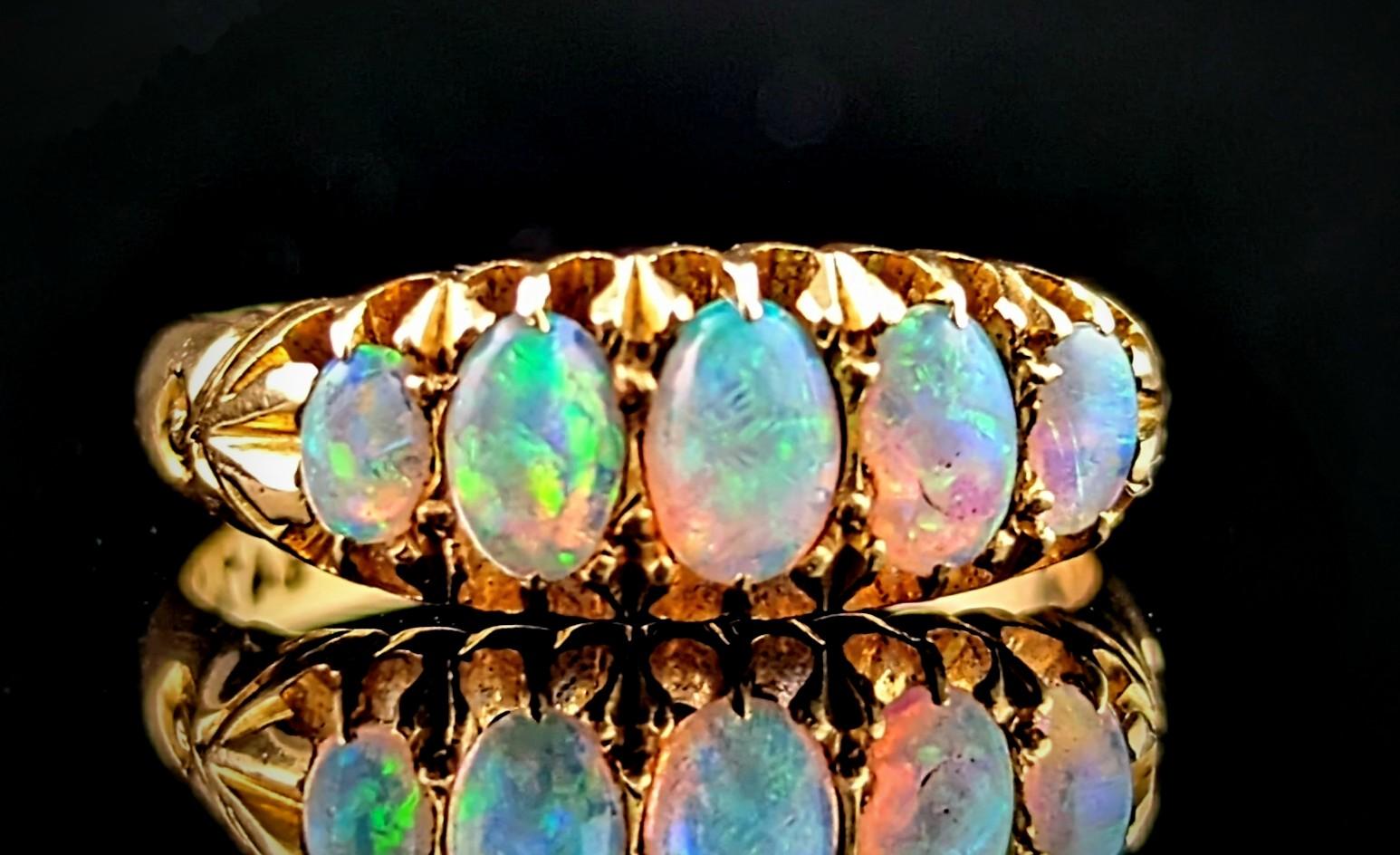 You can't help but be enchanted by this gorgeous antique, early 20th century opal ring.

A rich 18ct yellow gold band with a boat head style setting and decorative carved shoulders.

The face is set with five beautiful opal cabochons, the largest to