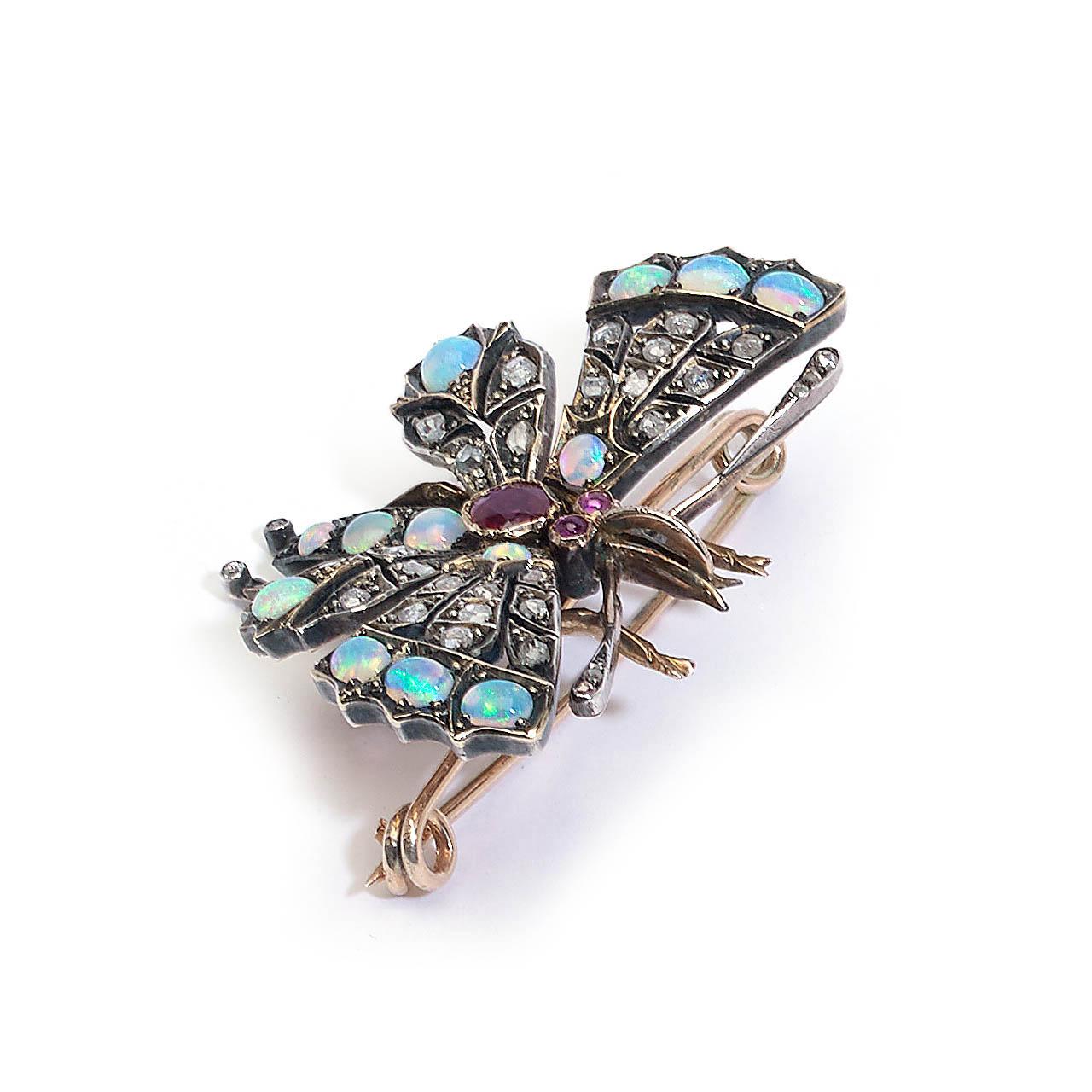 An antique opal, ruby and diamond butterfly brooch, with opals set in the wings and abdomen, a faceted ruby set in the thorax, cabochon rubies set in the eyes and rose-cut diamonds set in the wings and antennae, with an approximate total diamond