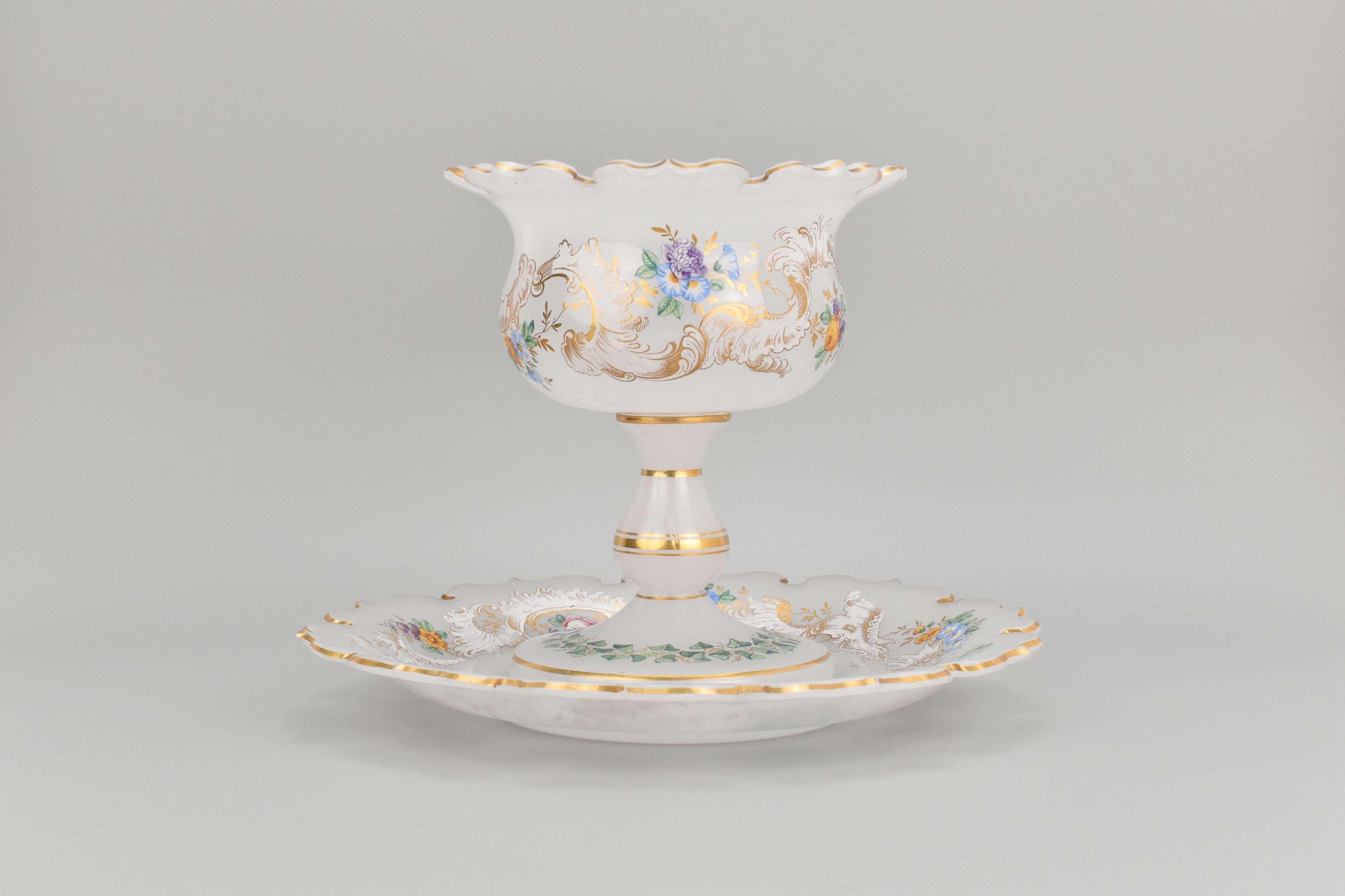 Este excepcional juego de servir de dos piezas, compuesto por un cuenco tazza y su plato o platillo a juego, está fabricado en vidrio opalino blanco lechoso y data de hacia 1850. Fabricado por vidrieros bohemios de mediados del siglo XIX, el
