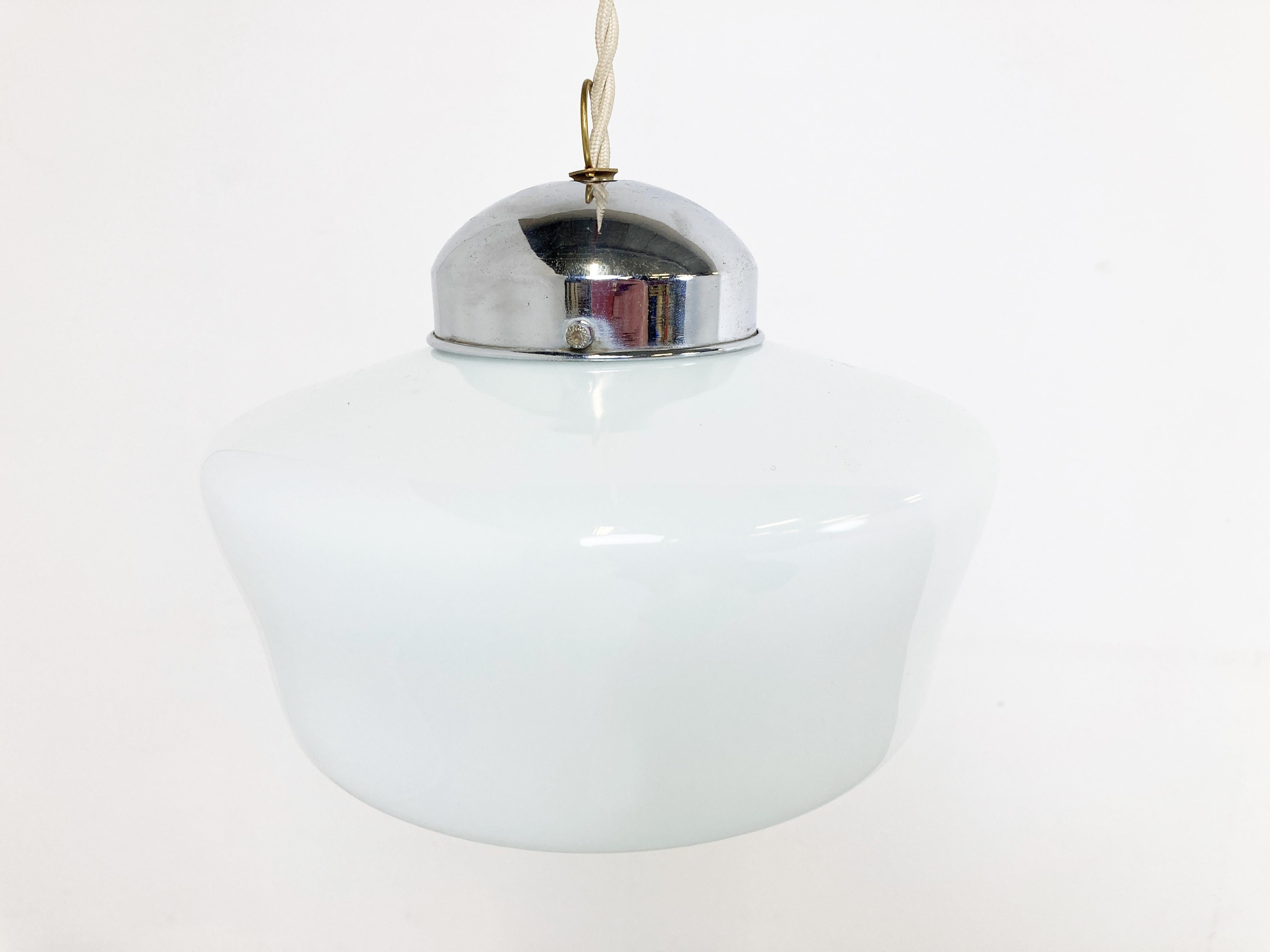 Antike Art-Deco-Hängeleuchte für den Flur.

Diese Lampe ist sehr typisch für die Art-Deco-Ära und wurde häufig in Fluren, Büros oder größeren öffentlichen Räumen aufgehängt.

Die Lampe hat die originale vernickelte Schirmhalterung. Die Länge kann so
