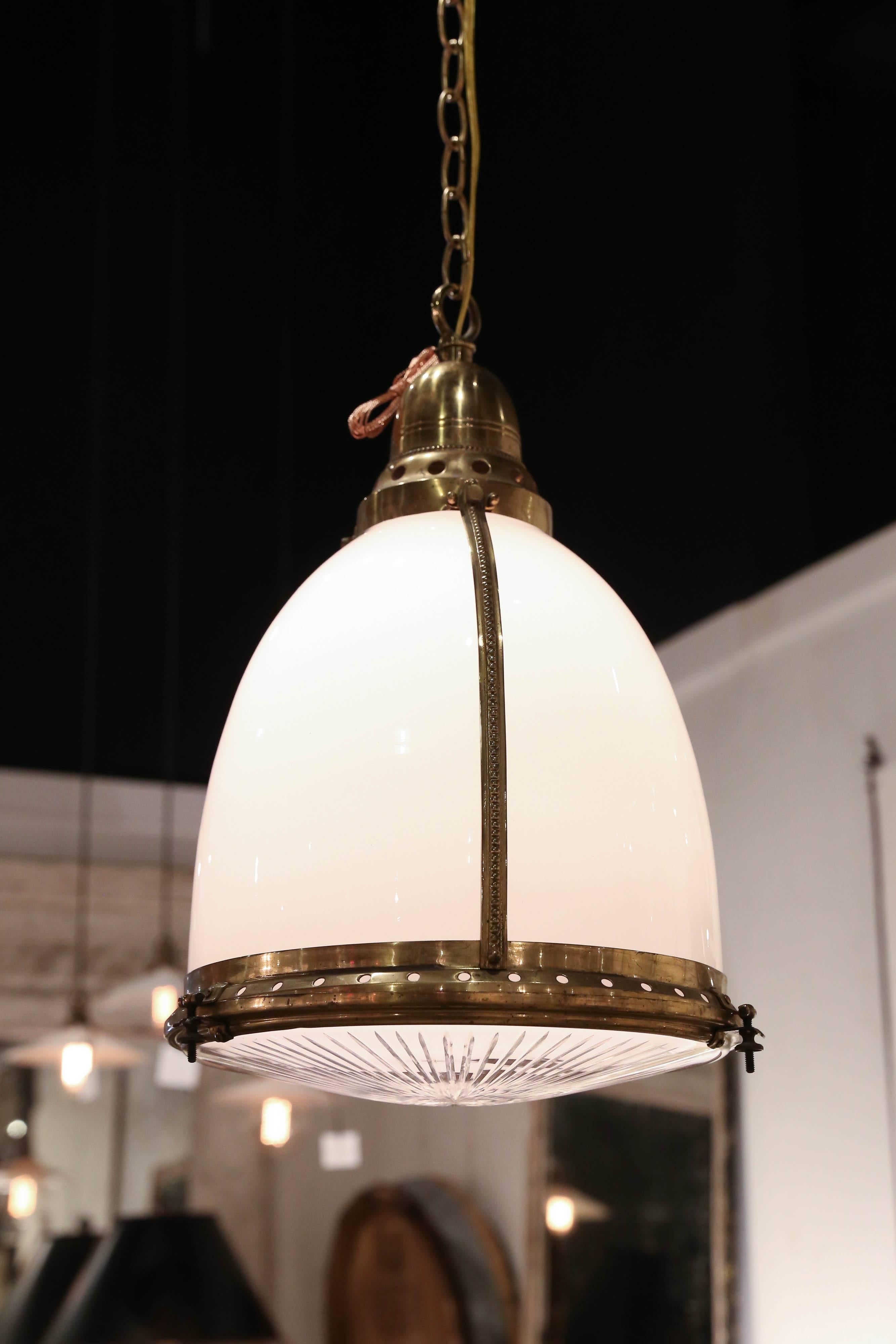 An antique pendant fixture of white and clear etched glass, banded and capped with brass and suspended on a 48