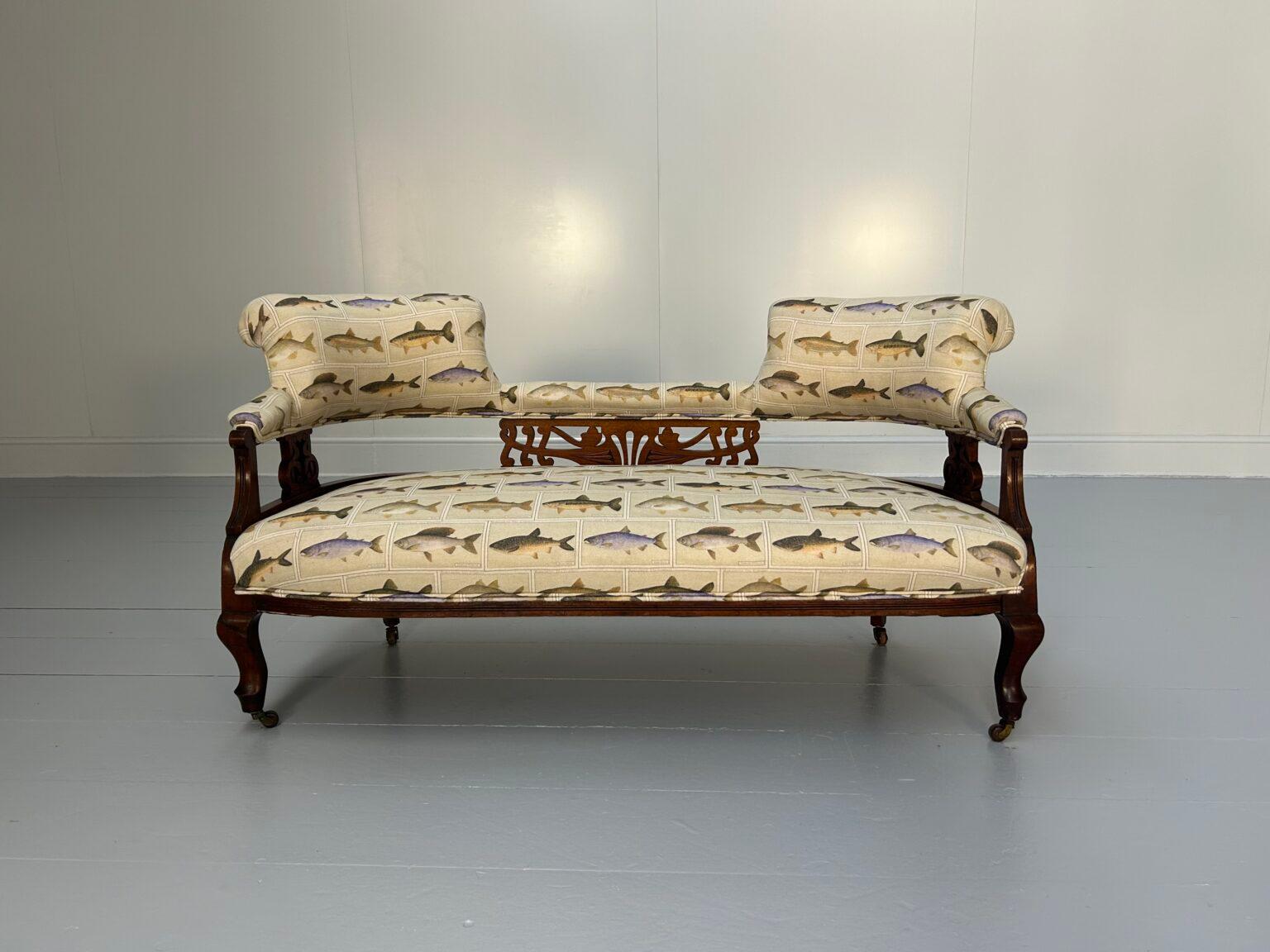 On offer on this occasion is a superb, antique Open-Back compact 2-Seat Sofa, dressed in a stunning, striking and unashamedly-eccentric fish-print linen-fabric, and with oak-woodwork and porcelain-castors.
 
As you will no doubt be aware by your