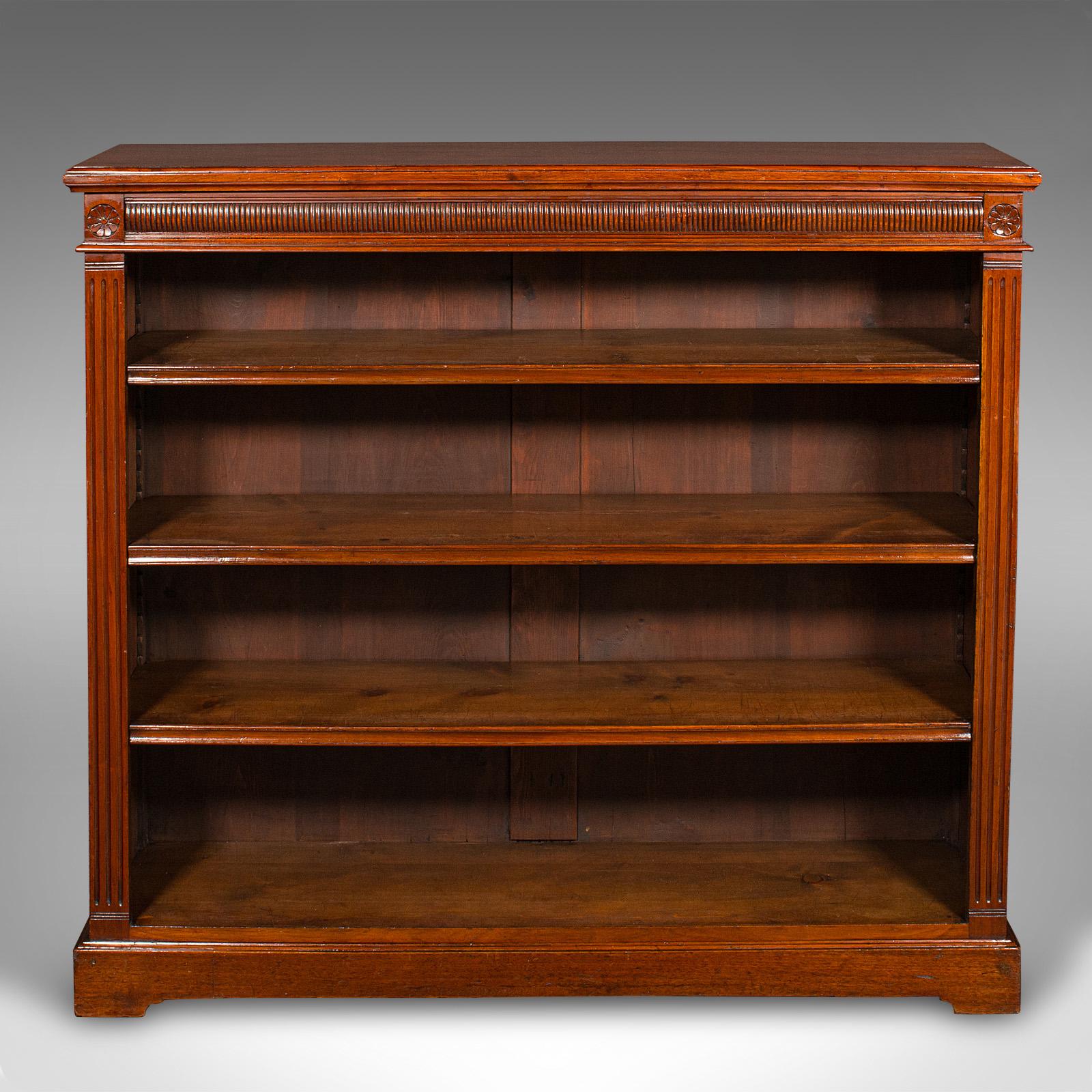 This is an antique open bookcase. An English, walnut bookshelf cabinet, dating to the late Victorian period, circa 1900.

Stout and purposeful bookcase, with a decorative flourish
Displays a desirable aged patina and in good order
Select walnut