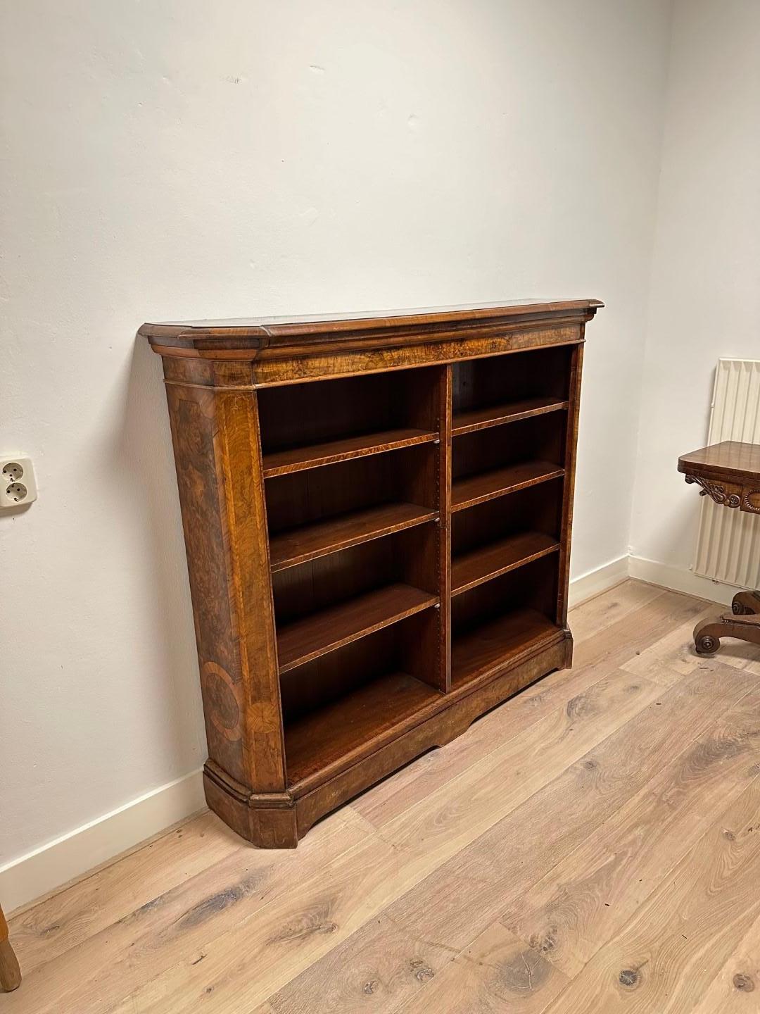 Beautiful open bookcase in burl walnut. The sides are slightly curved and inlaid. Beautiful warm color. The cabinet has a total of 6 adjustable shelves. Originally the cupboard  had doors.

Origin: England
Period: Approx. 1850
Size: 144cm x d.30cm x