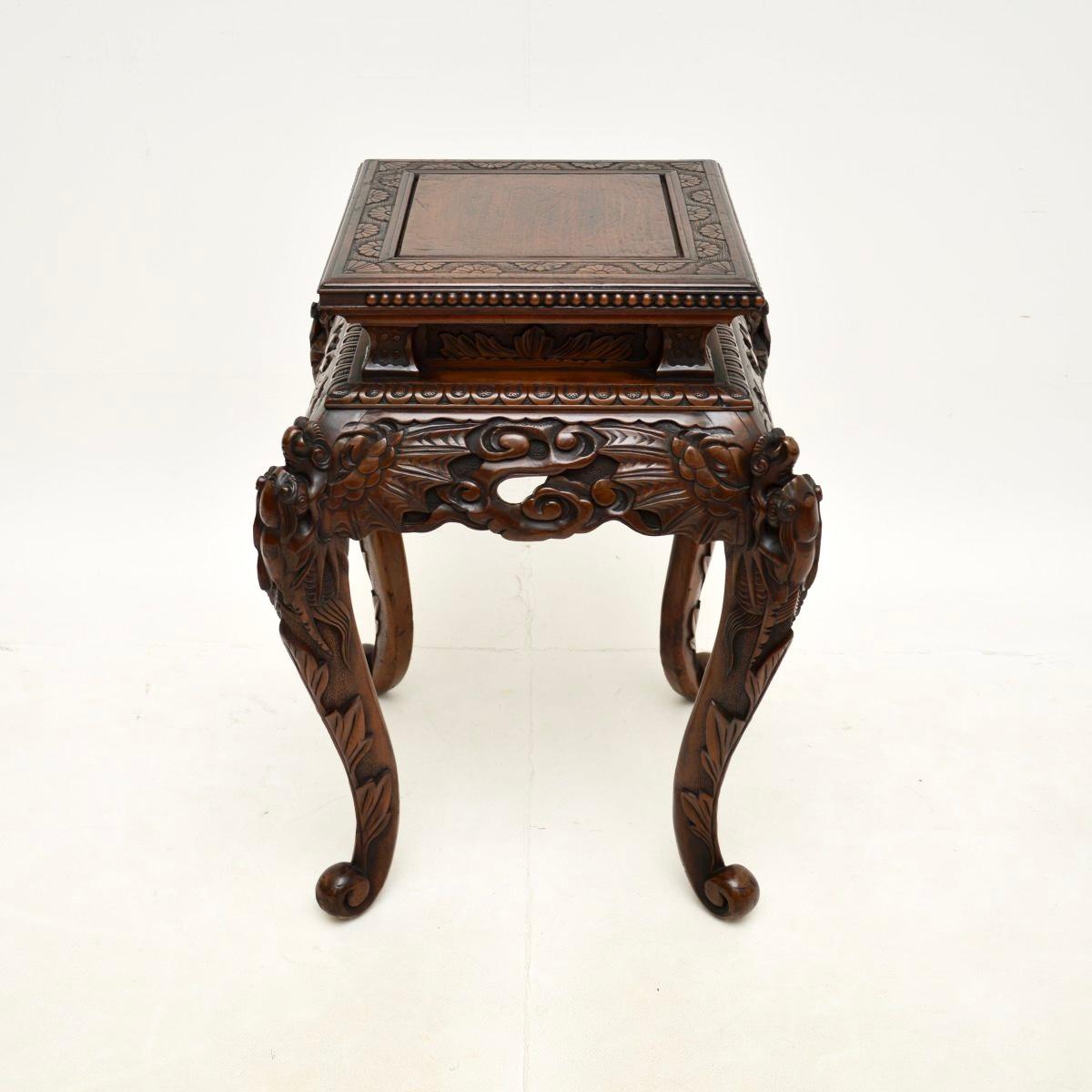 Un superbe support à plantes / table d'appoint en bois sculpté oriental ancien. Cet objet a probablement été fabriqué en Chine aux alentours de la période 1890-1910.

La qualité est superbe, il est magnifiquement sculpté dans du bois dur. Les coins