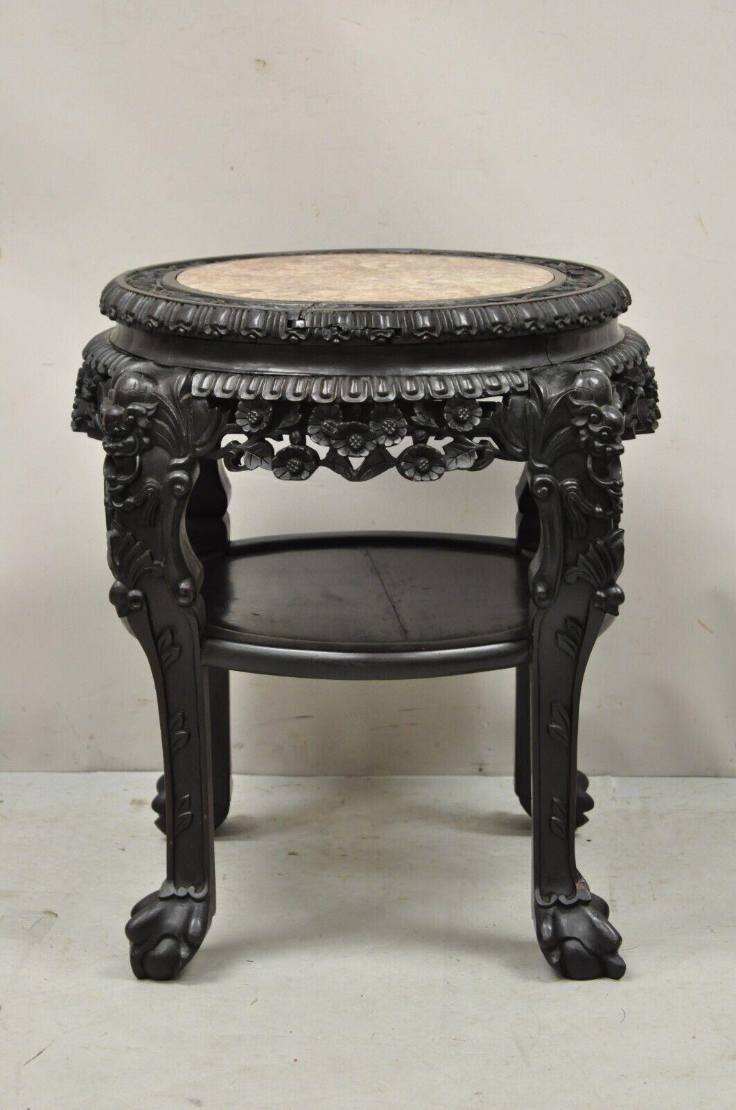 Antique Oriental Chinese carved hardwood marble top foo dog side table. Item features a lower shelf, pink marble top, Foo dog carvings to legs, floral carved skirt, solid wood construction, nicely carved details, very nice antique item. Circa early