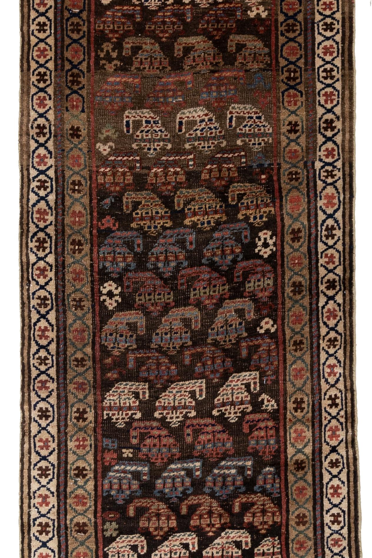 Age: circa 1930

Colors: black, brown, blue, gold, red

Pile: medium-full

Wear Notes: 2

Material: Wool on wool. 

This Kurdish runner was woven during the late 1800’s and features a dark background filled with rows of detailed boteh.