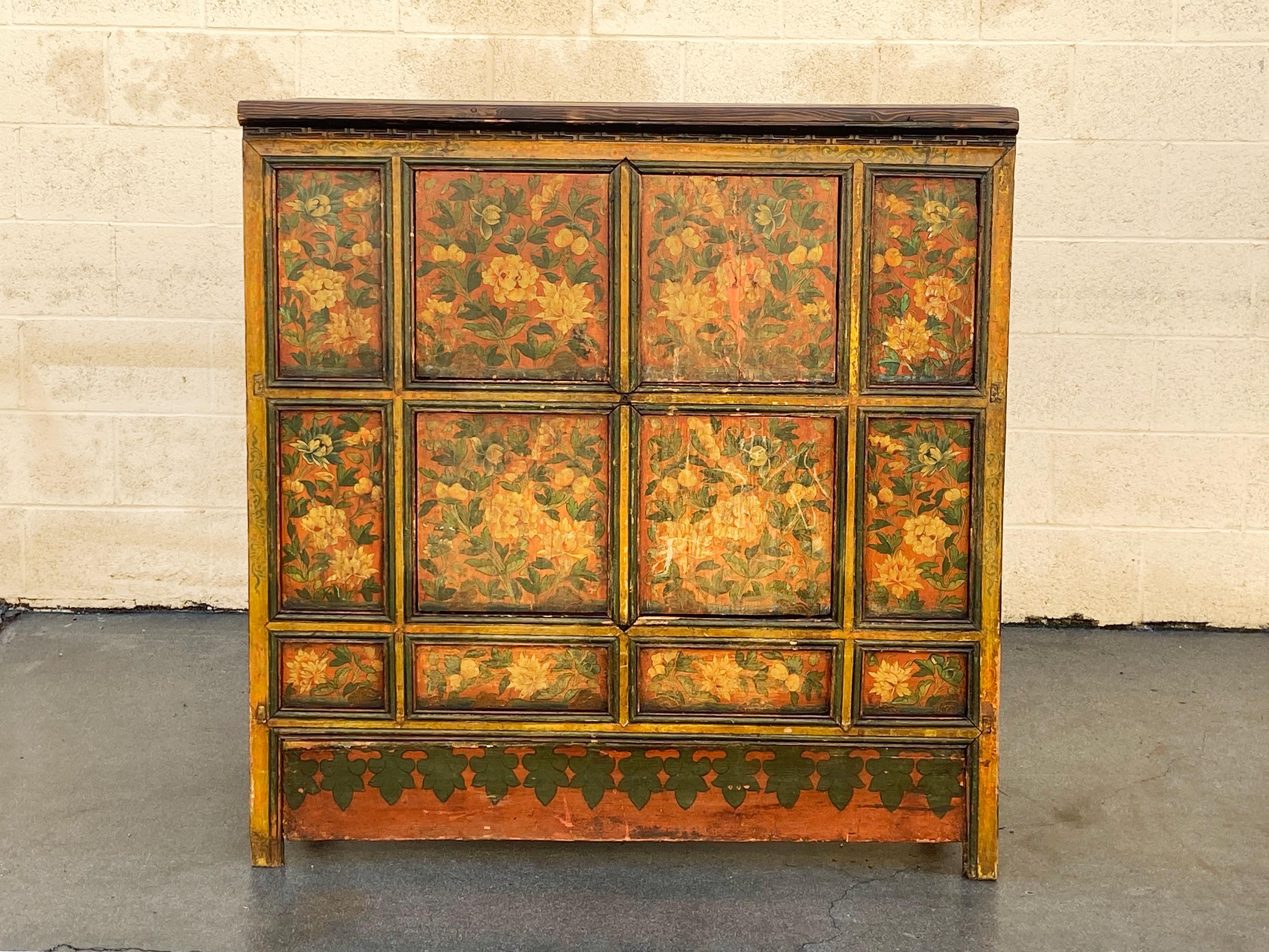 Antique hutch from India with beautiful Oriental inspired floral motif. Handmade with hand painted chrysanthemums and carved moulding. Features two shelves with double doors. 

Dimensions: 42.75