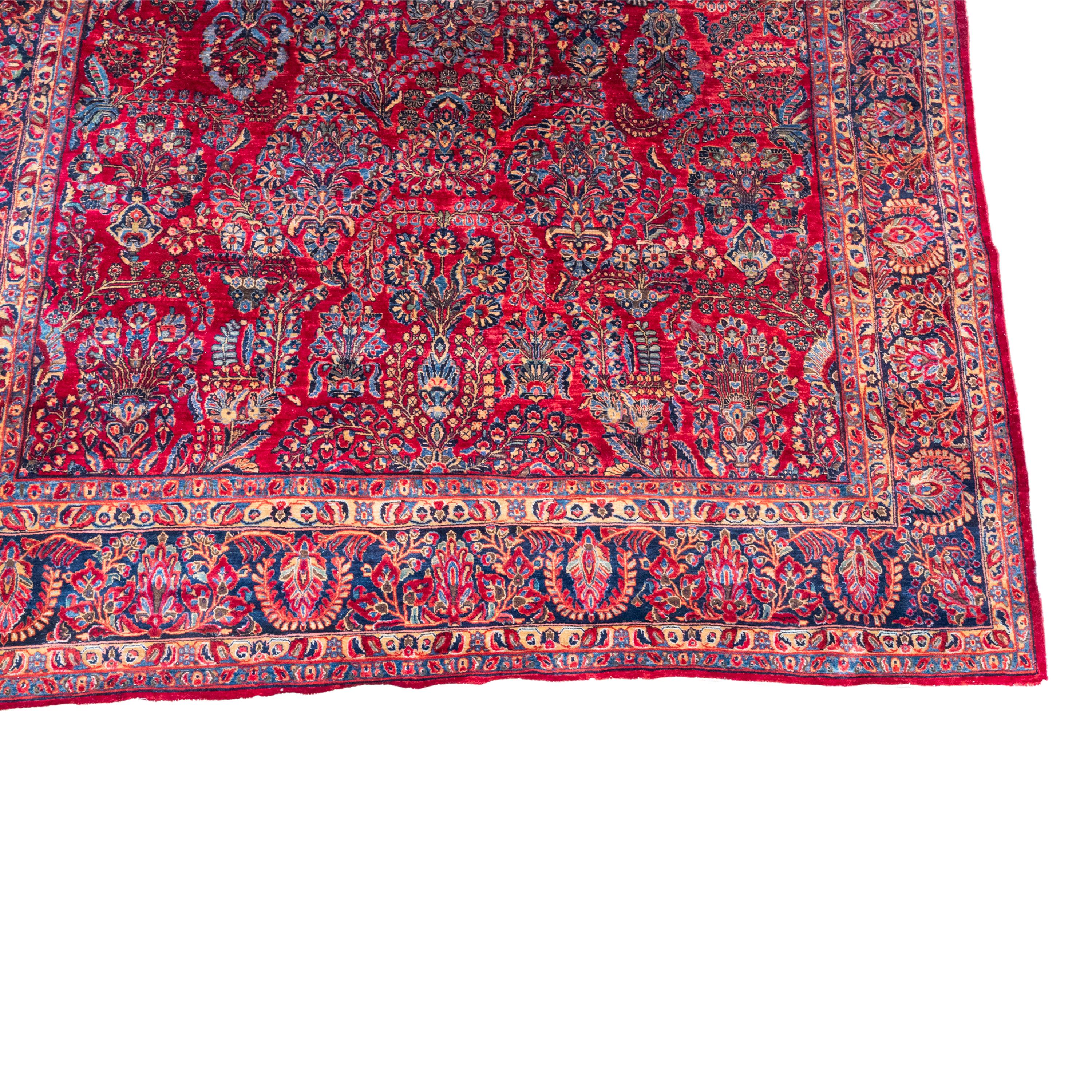 A fine antique palace size handwoven Persian Sarouk carpet, circa 1920. 
The carpet is 15ft in length by 9.75ft in width, it is finely woven with a high knot content, the carpet has a good full pile.
The red ground is is finely drawn with an allover