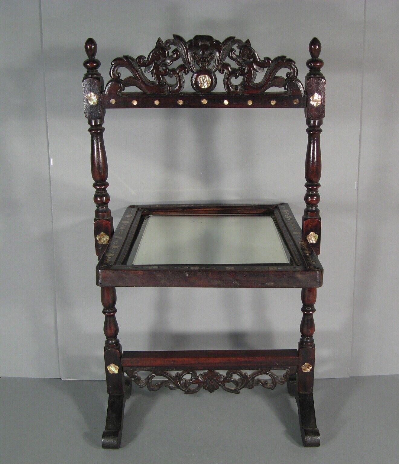 This impressive table psyche mirror, crafted in blackened wood with an Oriental style, dates back to the early 20th century. The ornate wooden pediment features carved and openwork designs of two stylized dragons and a bat, with decorative motifs of