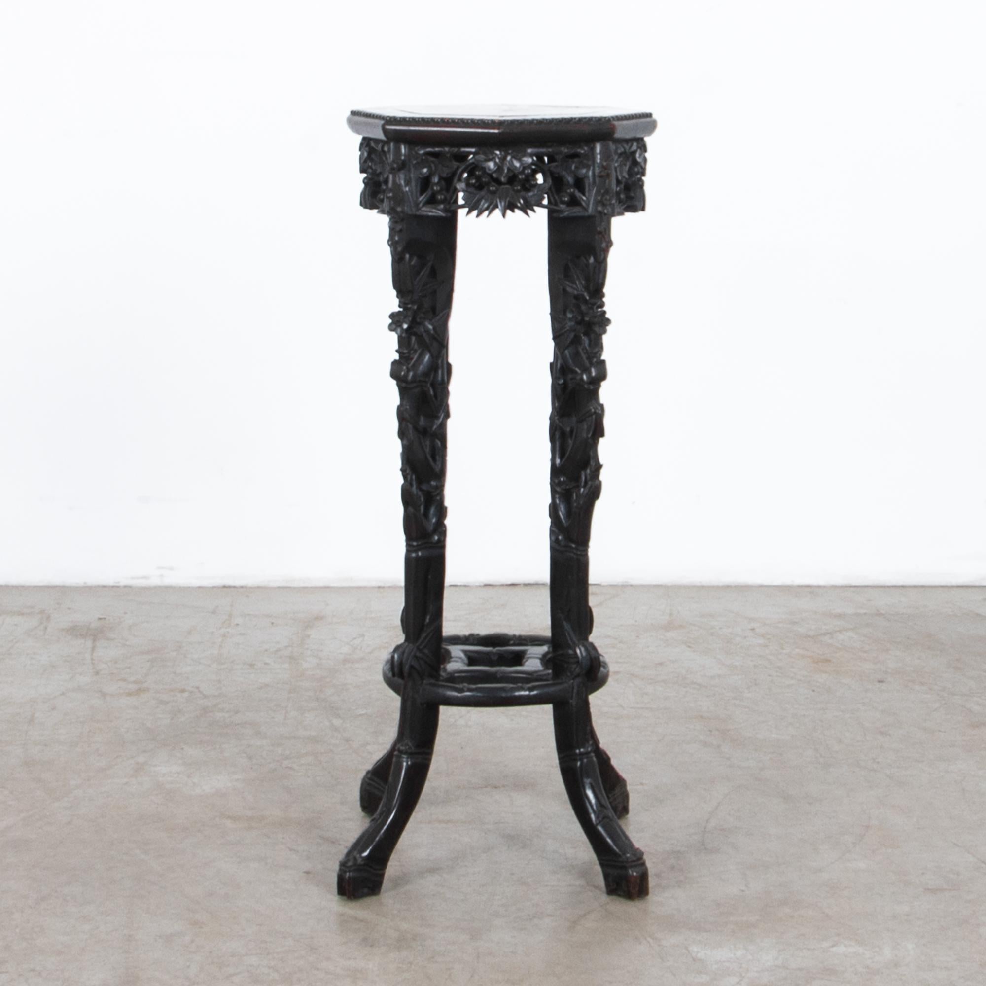 A carved rosewood table from France, circa 1900. Inspired by exotic locals, this table is carved with Asian inspired motifs and topped with Belgian red marble. A deep carved floral motif and zoomorphic feet present a fusion of styles, in a practical