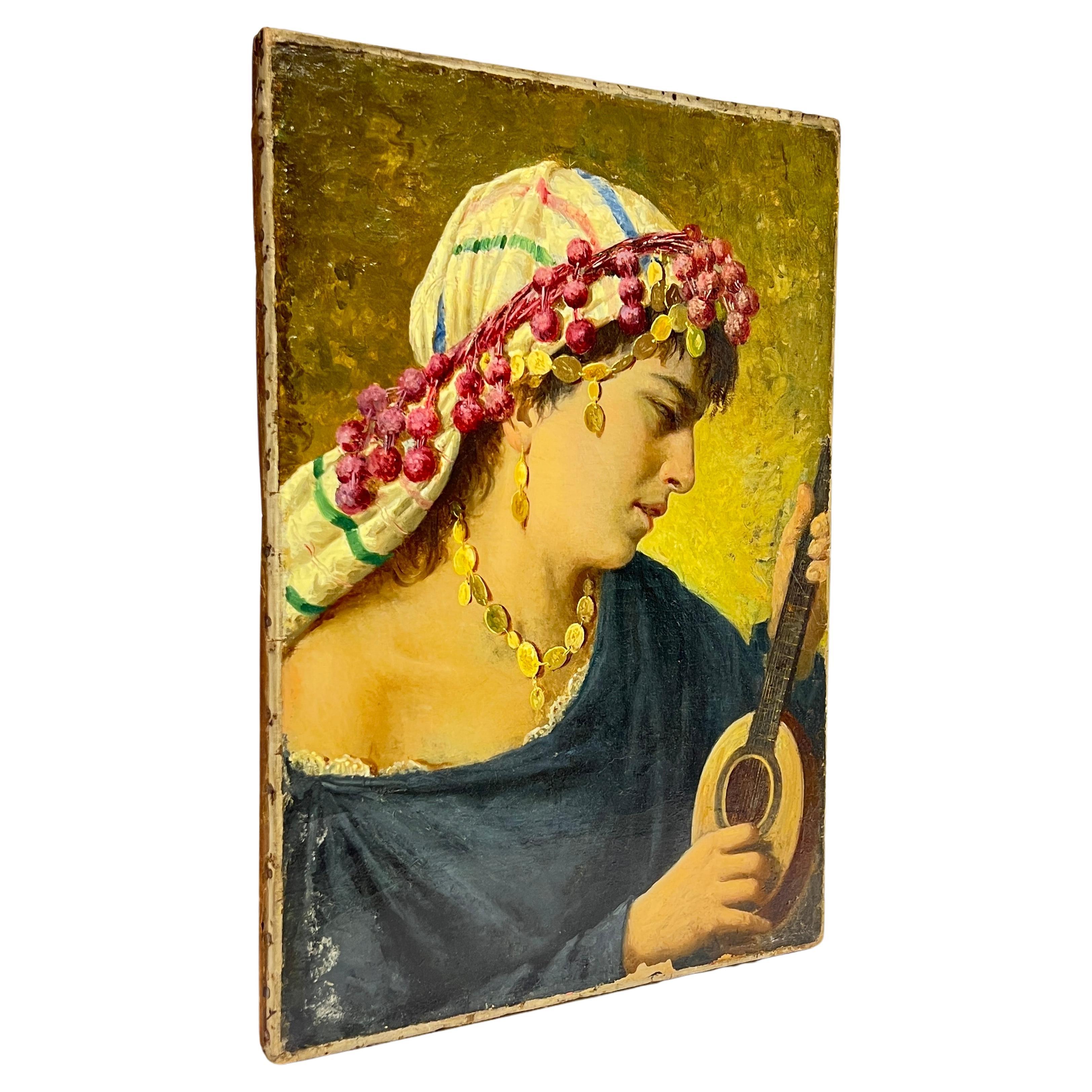 Our antique oil on canvas from the Orientalist period, 13 1/2 by 19 1/4 inches, depicts a female playing a small stringed instrument, wearing yellow scarf with blue, red and green stripes, held in place with red head band with tassels, and wearing