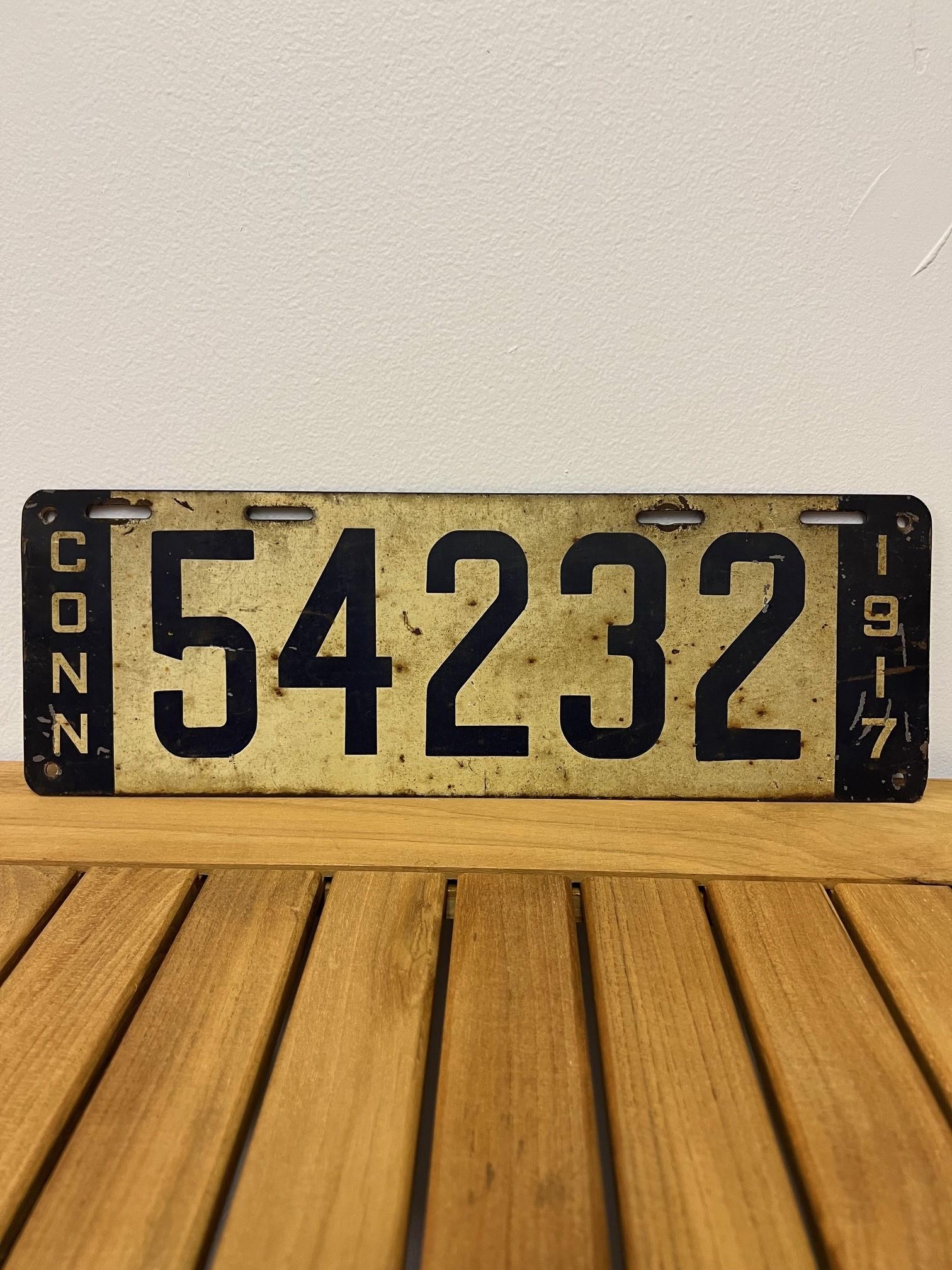 This is an original 1917 Connecticut automobile license plate with a six digit number 54232. It would look great on a classic car or a nice addition to a license plate collection. It's in good condition but has some marks and scratches shown in the