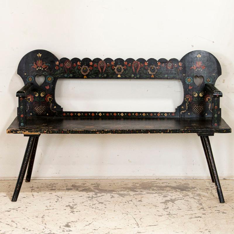 This delightful bench still maintains the original black paint, with a lively array of flowers and flourishes in the traditional Folk Art style of the era. The bright colors of red, green, yellow and blue were favorites in Romania, and their