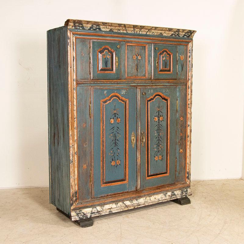 This exceptional 200 year old original painted armoire is a rare find. The blue painted finish is all original; the doors were even painted with two seperate designs possibly indicating a his/her hanging rack as there are initials on doors as well.