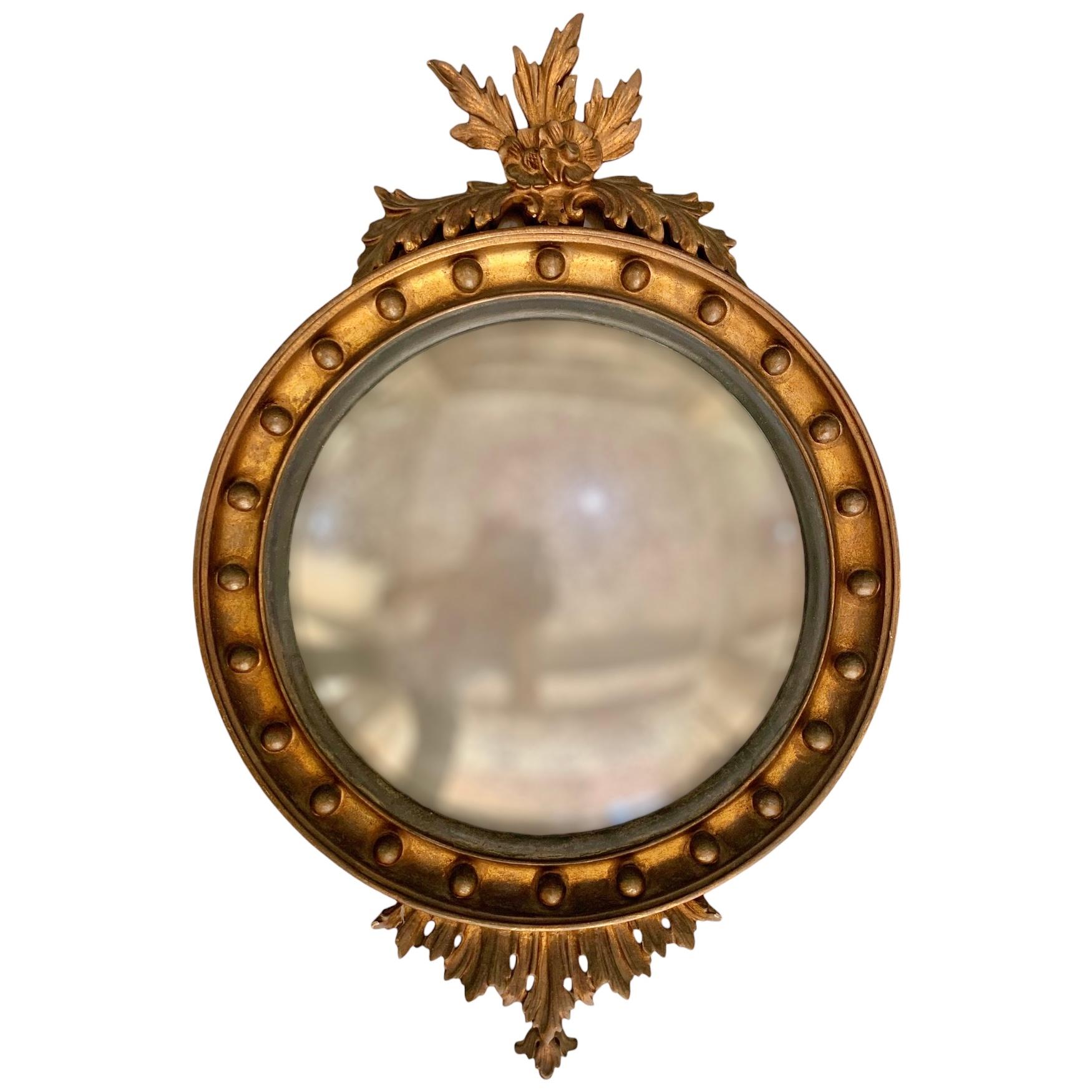 LARGE GILT NEOCLASSICAL MIRROR WITH A CARVED DECORAION

in its original condition and gilding despite the age

the circular plate in a receded frame applied with balls

France, early 19th Century-