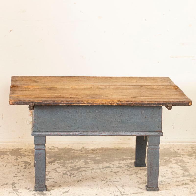 This original gray painted coffee table is a great find for someone looking to maximize a small space. While this small-scale coffee table will suite a cozy setting, it has hidden storage beneath the sliding top. Need to hide magazines, remotes,